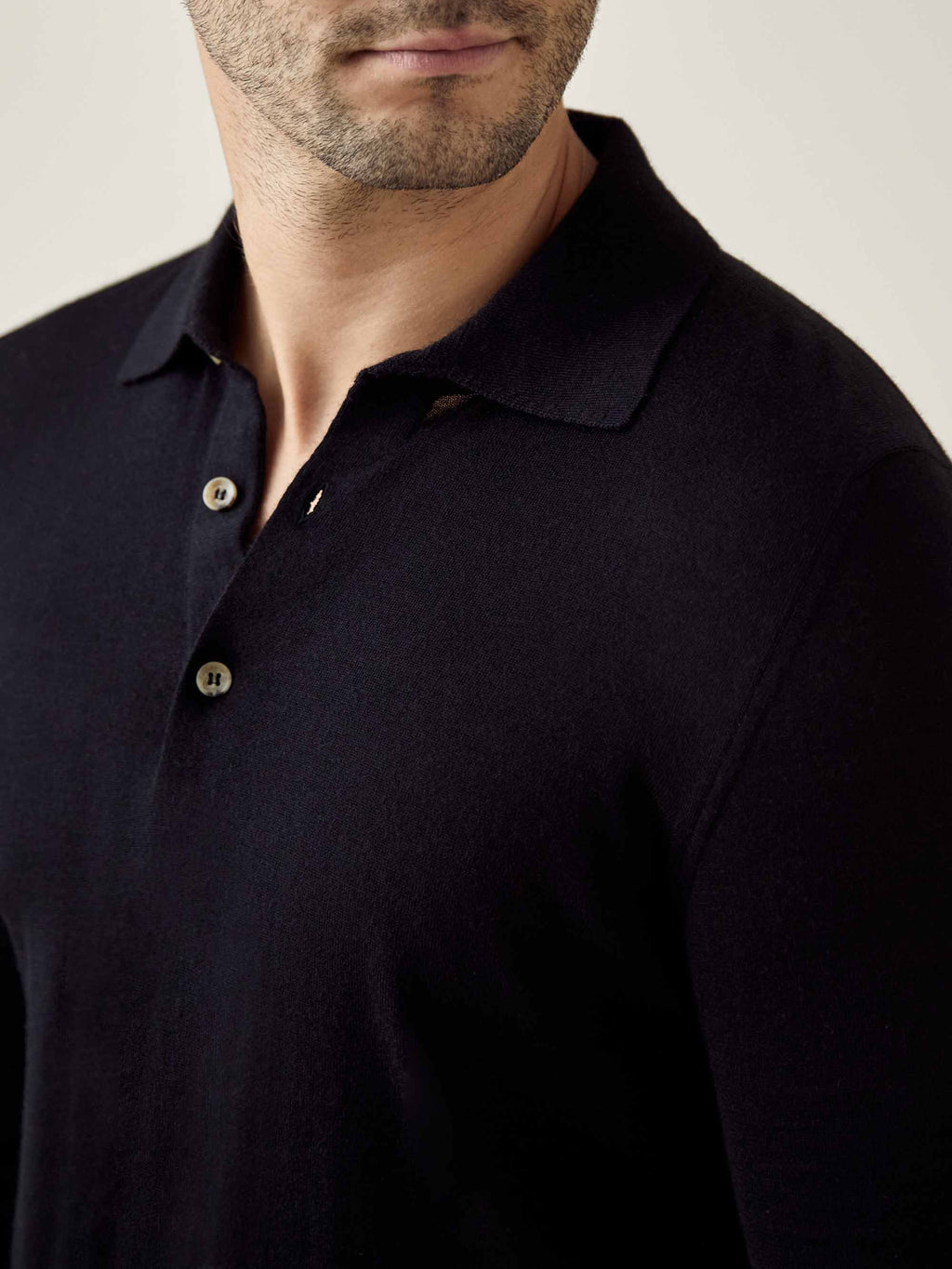 Close-up of the Luca Faloni Fine Silk Cashmere Polo in black, highlighting the spread collar and button placket.