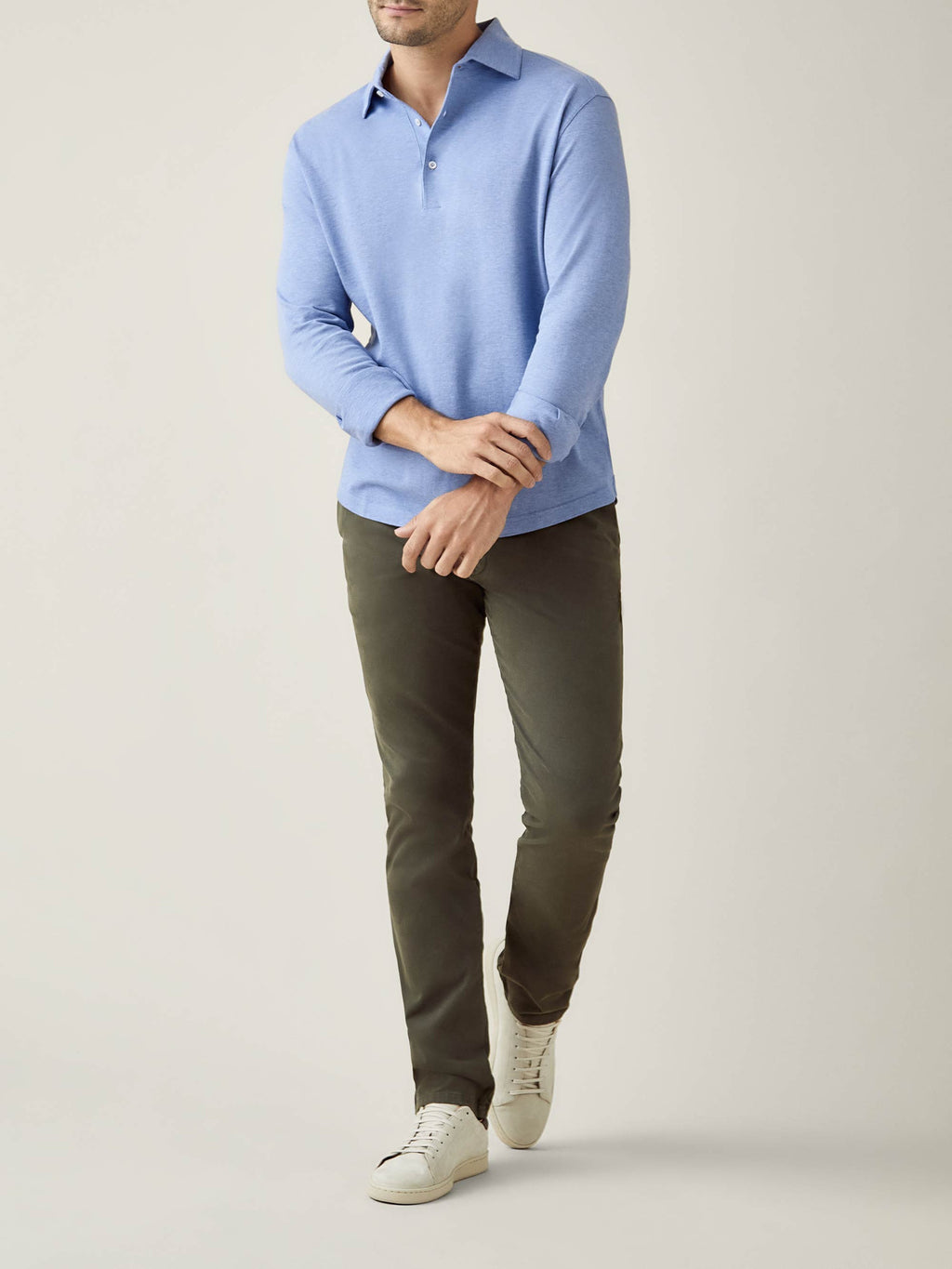 Full body shot of a model wearing the Brera Piqué Polo Shirt in light blue with dark trousers.