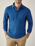 Model from the waist-up wears the long-sleeved Brera Piqué Polo Shirt in Royal Blue with the cuffs rolled up.
