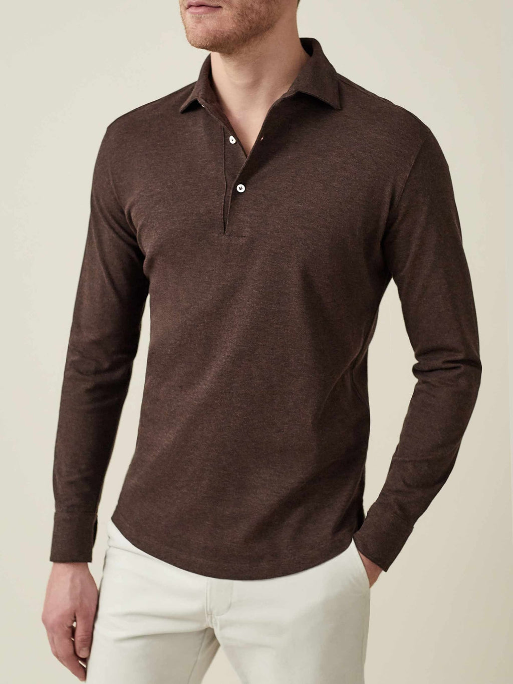 Front view of a model wearing the Brera Piqué Polo Shirt in chocolate brown with white trousers.