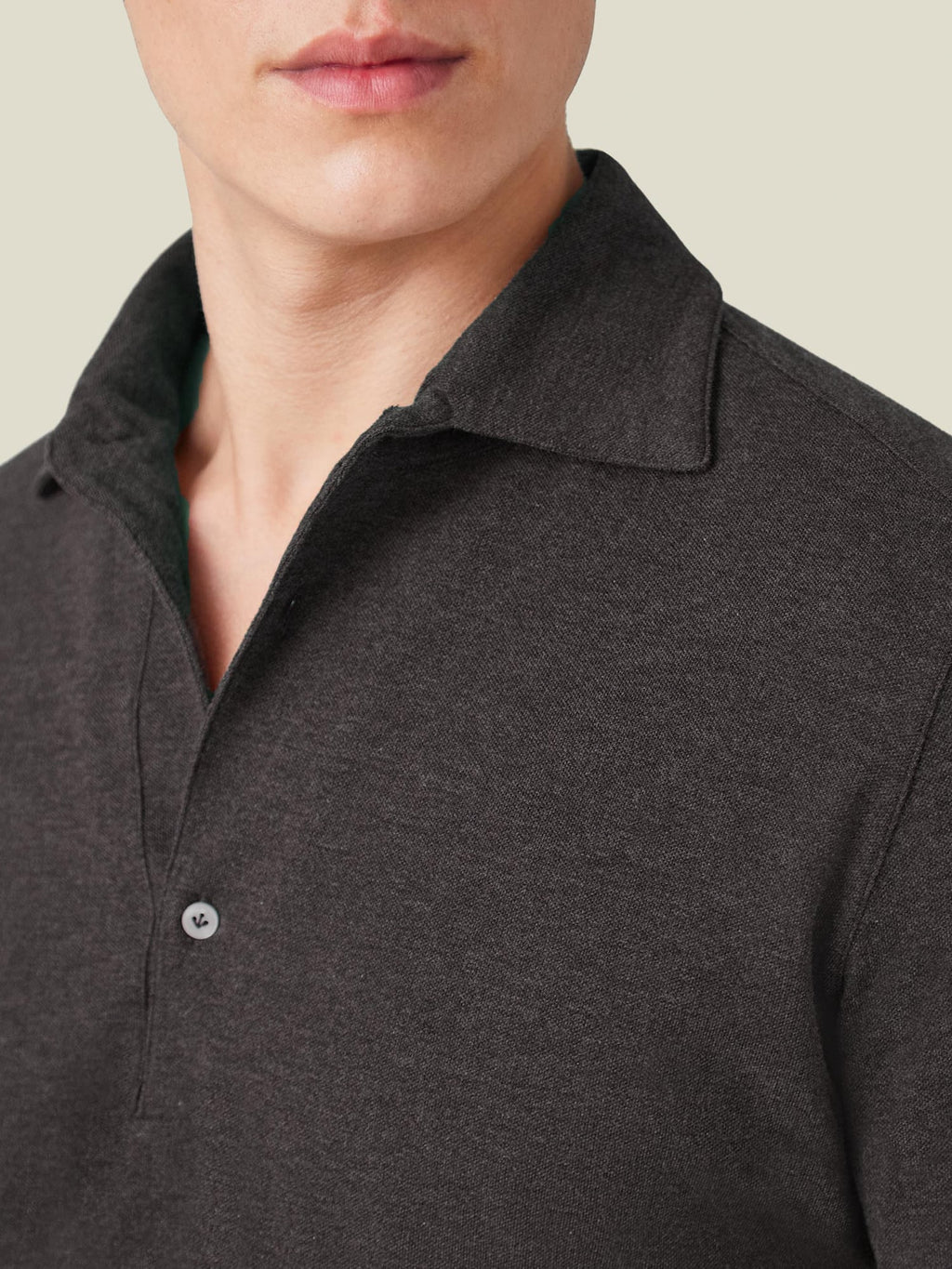 A close-up of the Brera Piqué Polo Shirt in Charcoal Grey, highlighting the soft cotton piqué fabric and one-piece collar.