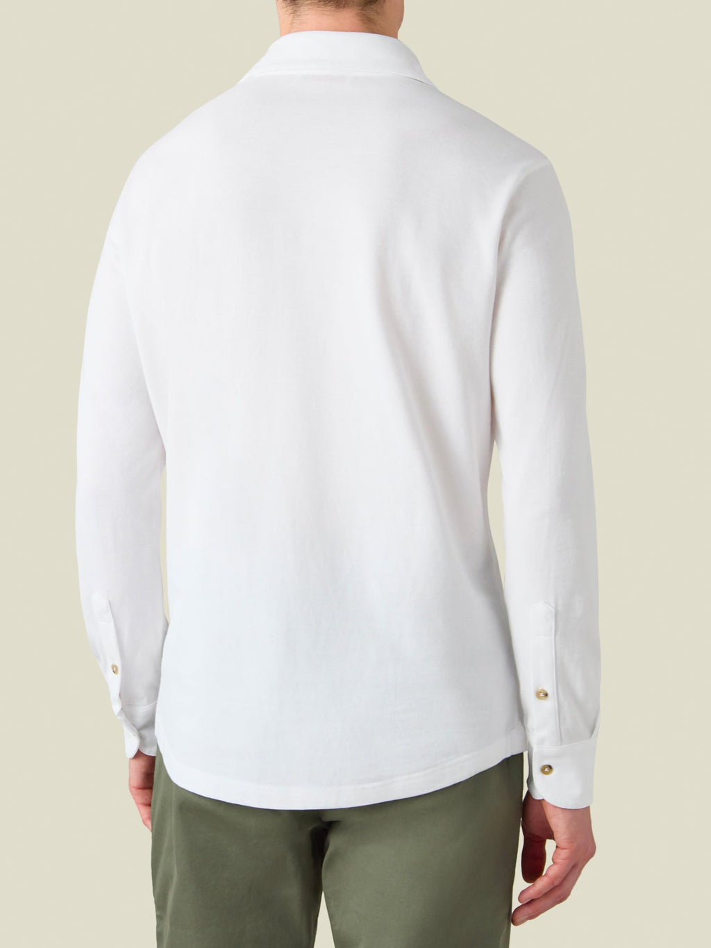 Man seen from behind wearing the white Brera Piqué Polo Shirt with green trousers.