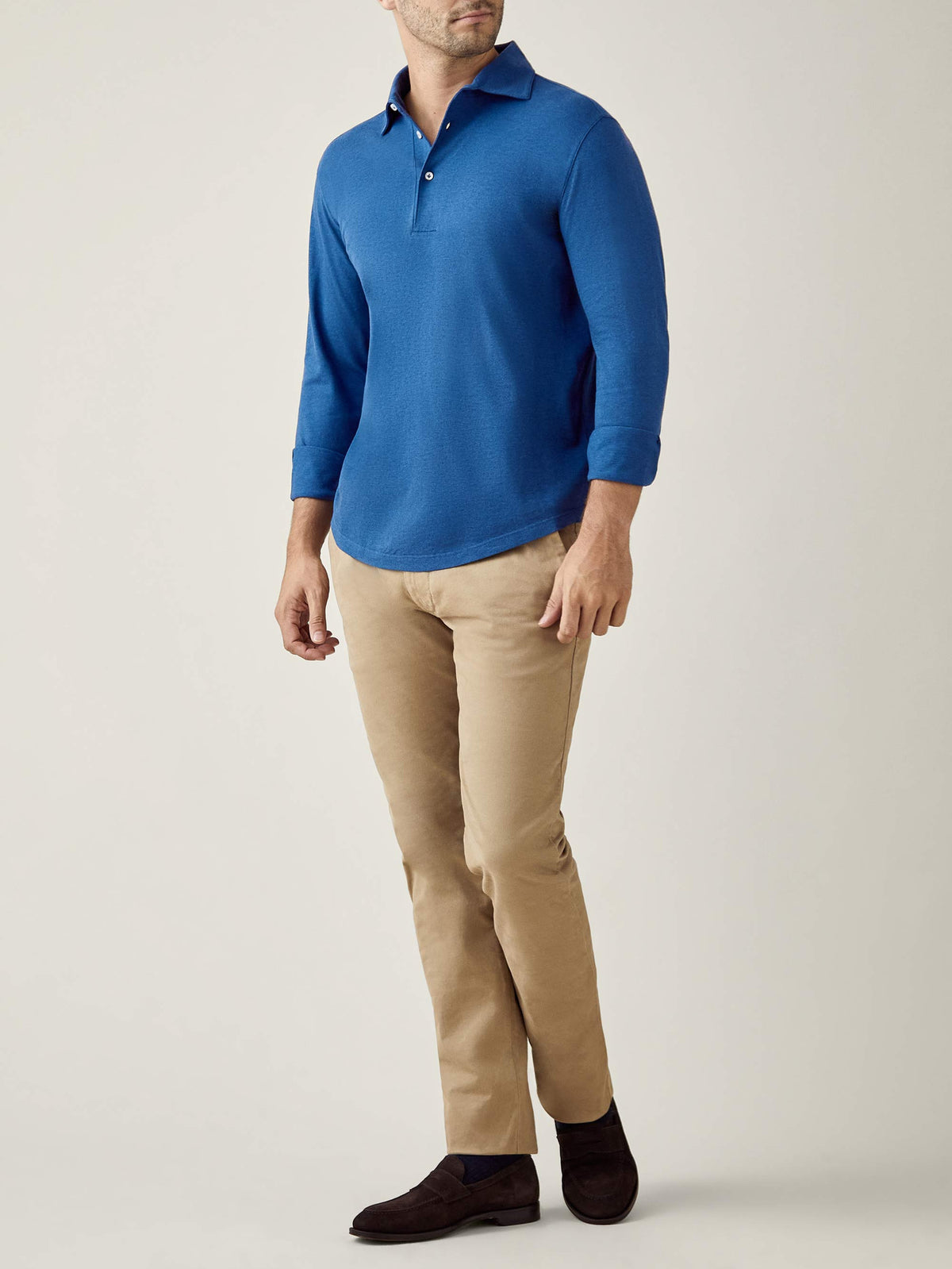 Model wearing the royal blue Brera Piqué Polo Shirt with beige trousers and dark brown shoes against a plain background.