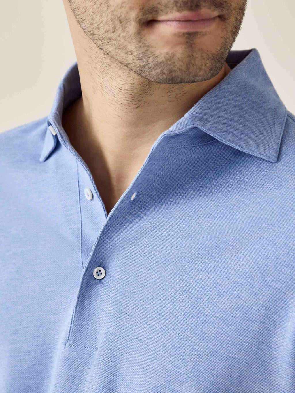 Close-up of the light blue Brera Piqué Polo Shirt, detailing the one-piece Paramontura collar and mother of pearl buttons.
