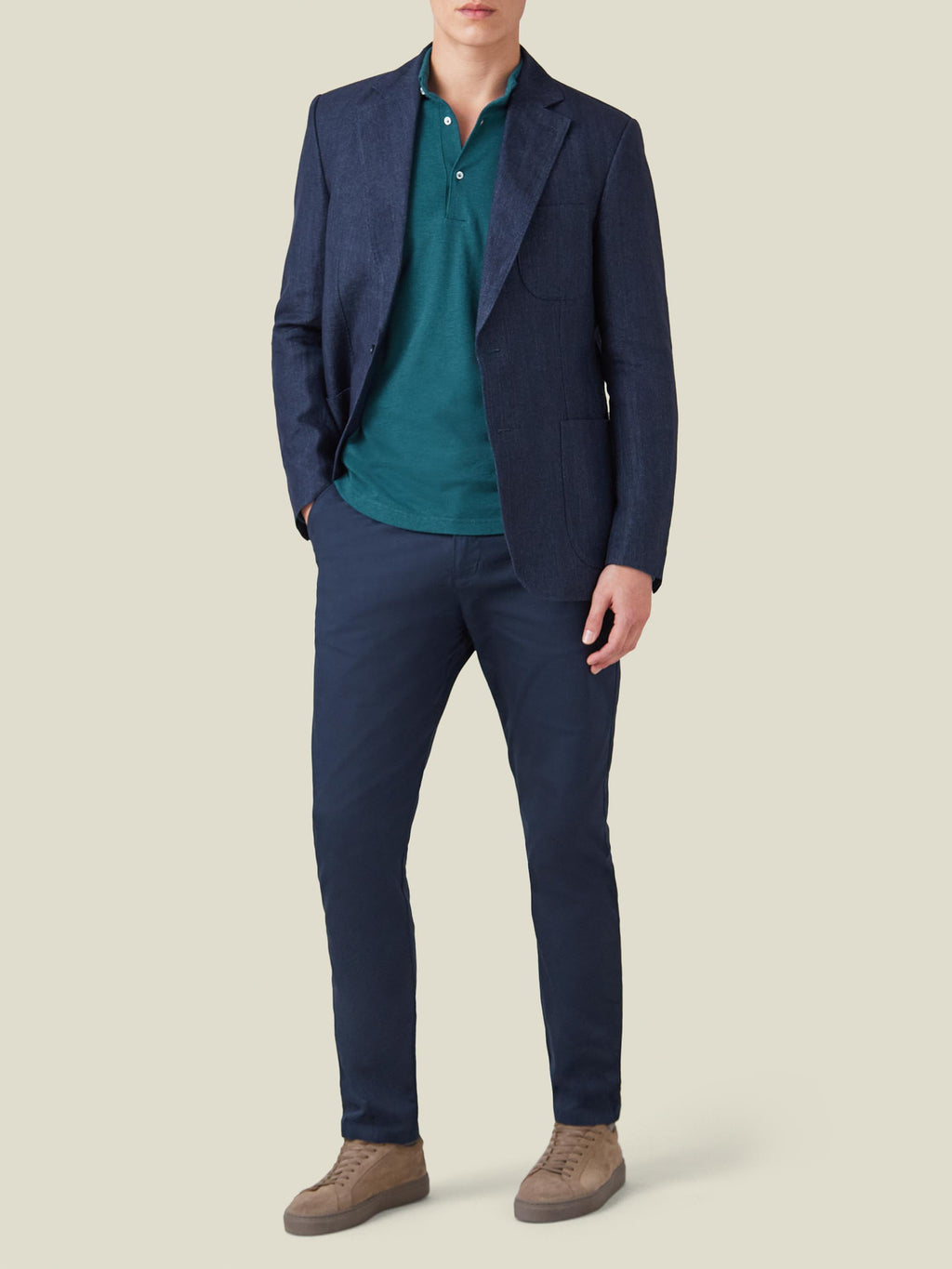 Full view of a model wearing Luca Faloni's Forest Green Brera Piqué Polo Shirt under a navy blazer with navy trousers.