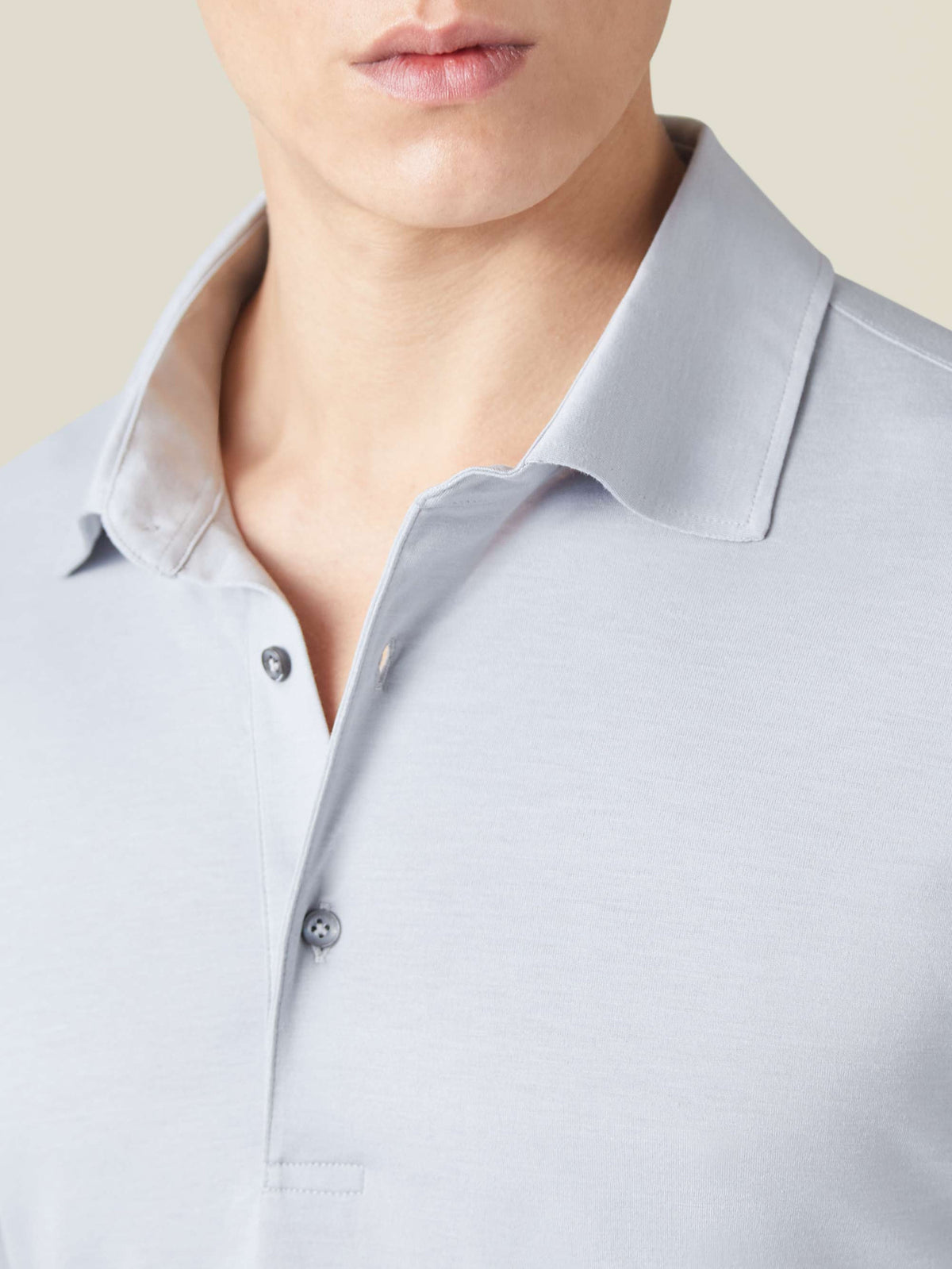 Close-up of the light grey Amalfi Silk-Cotton Polo Shirt, detailing the collar, fabric, and mother-of-pearl buttons.