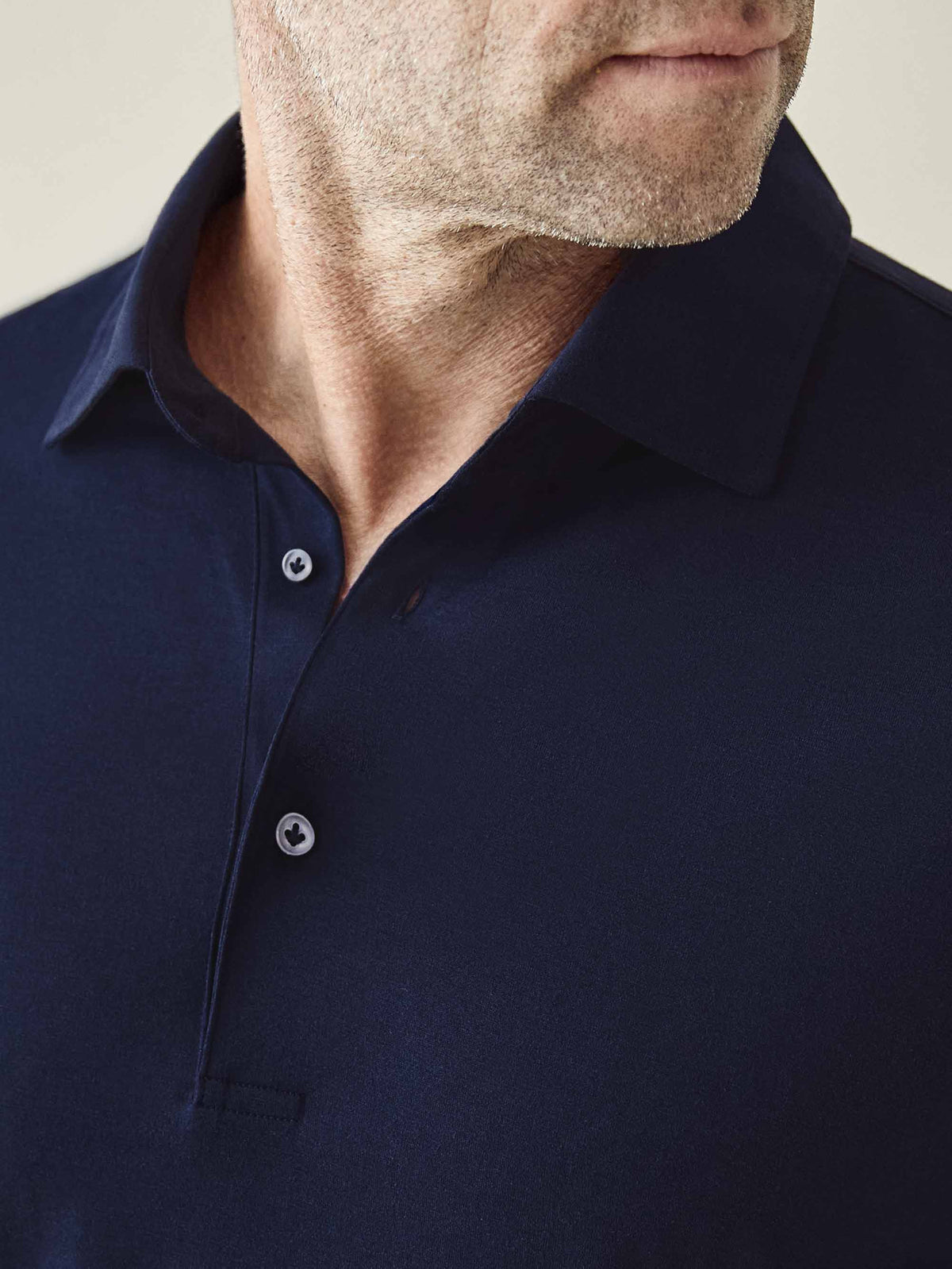 Close-up of a man wearing the Amalfi Silk-Cotton Polo Shirt in Midnight Blue, showing the collar and mother of pearl buttons.
