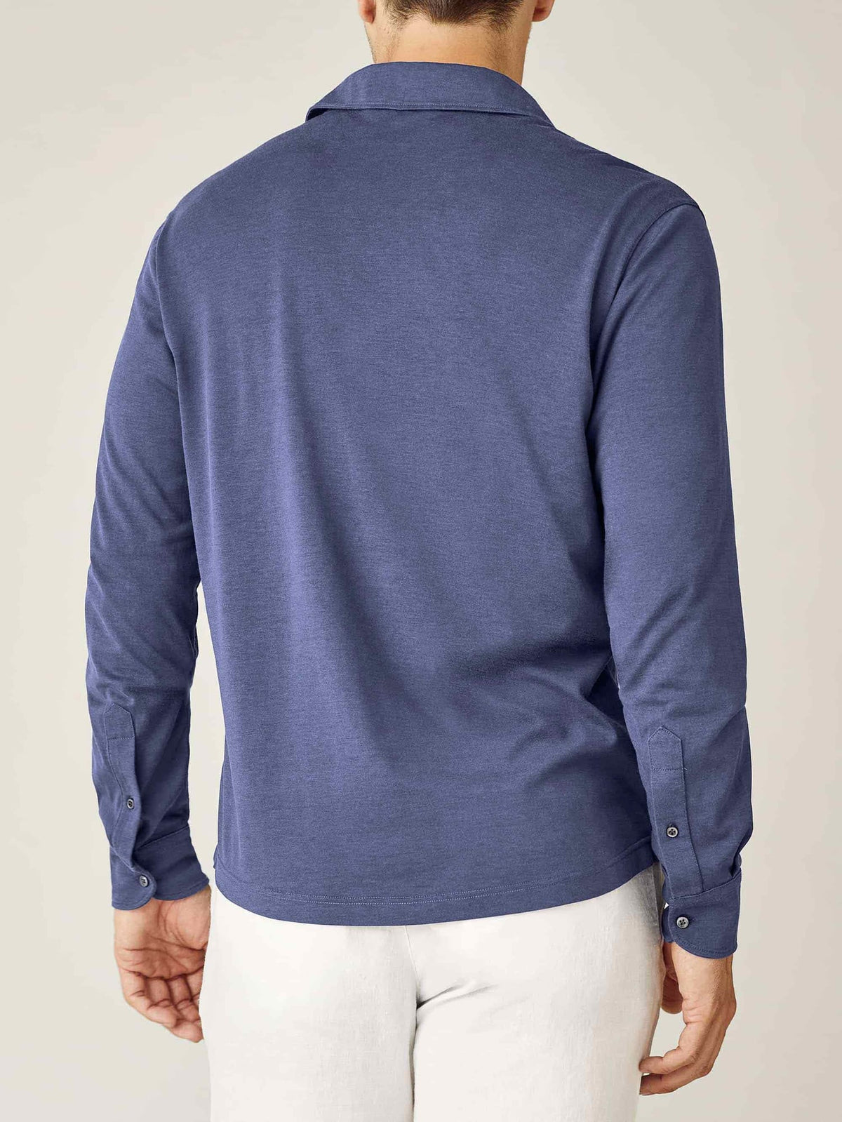Back view of a model wearing the Amalfi Silk-Cotton Polo Shirt in ocean blue.