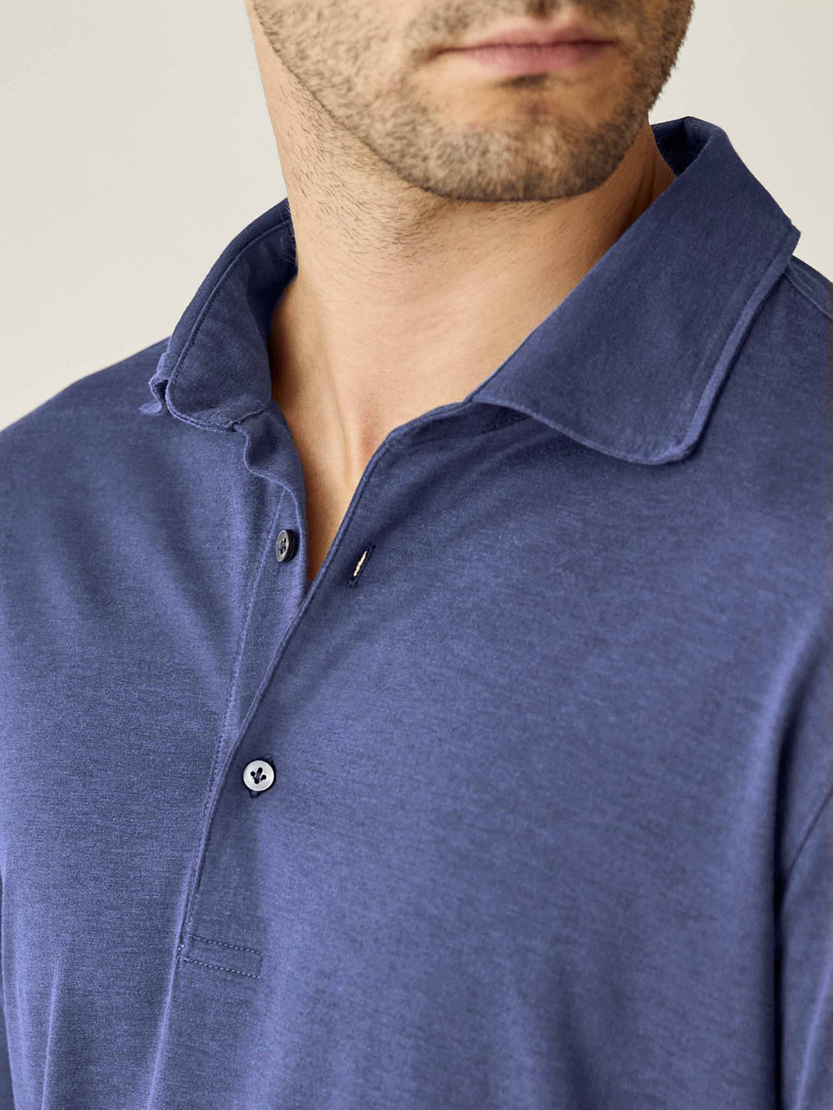 A close-up of the Amalfi Silk-Cotton Polo Shirt in Ocean Blue, showing the textured fabric, collar, and button placket.