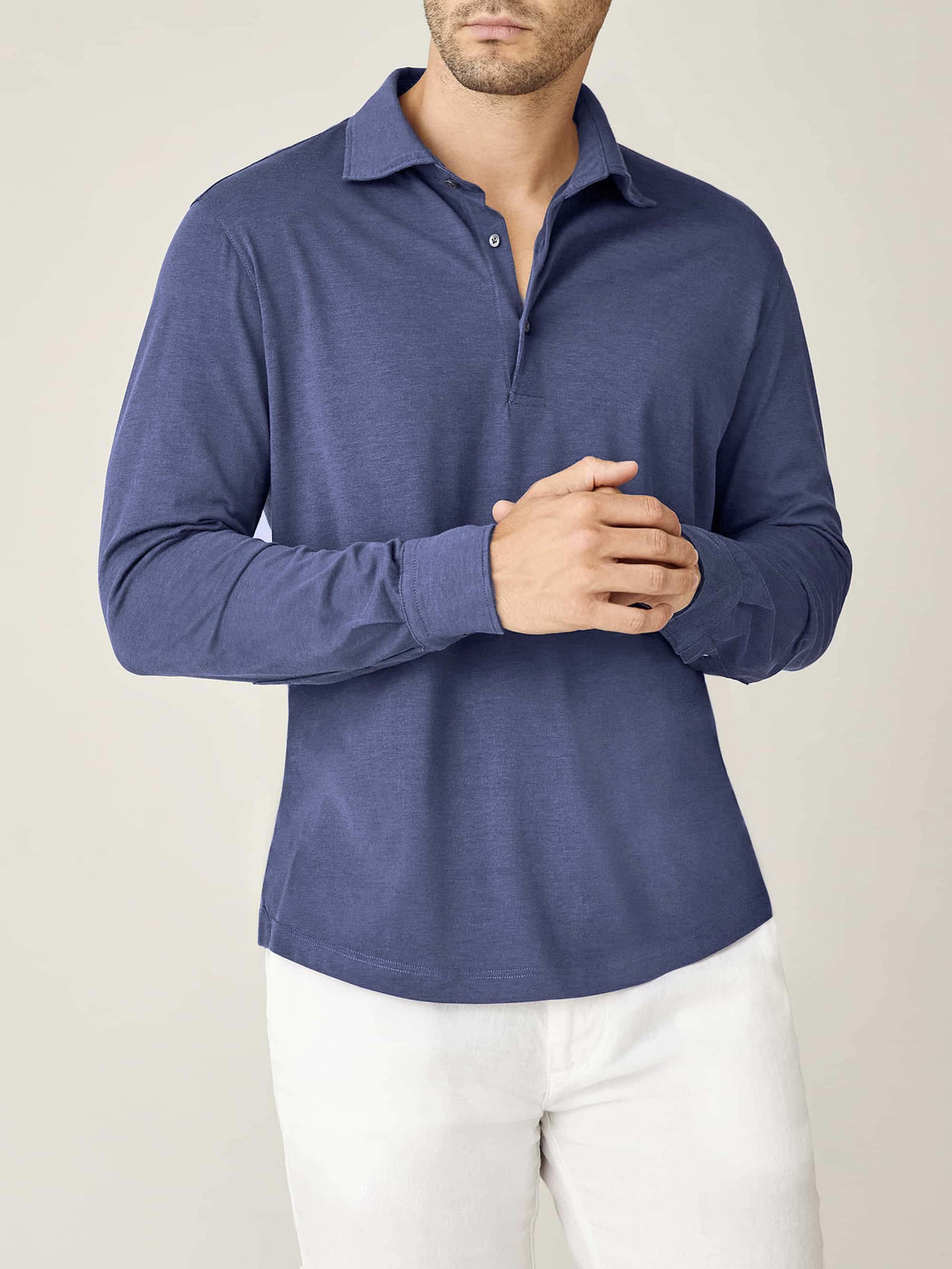 Front view of a man wearing the Amalfi Silk-Cotton Polo Shirt in ocean blue with white trousers.