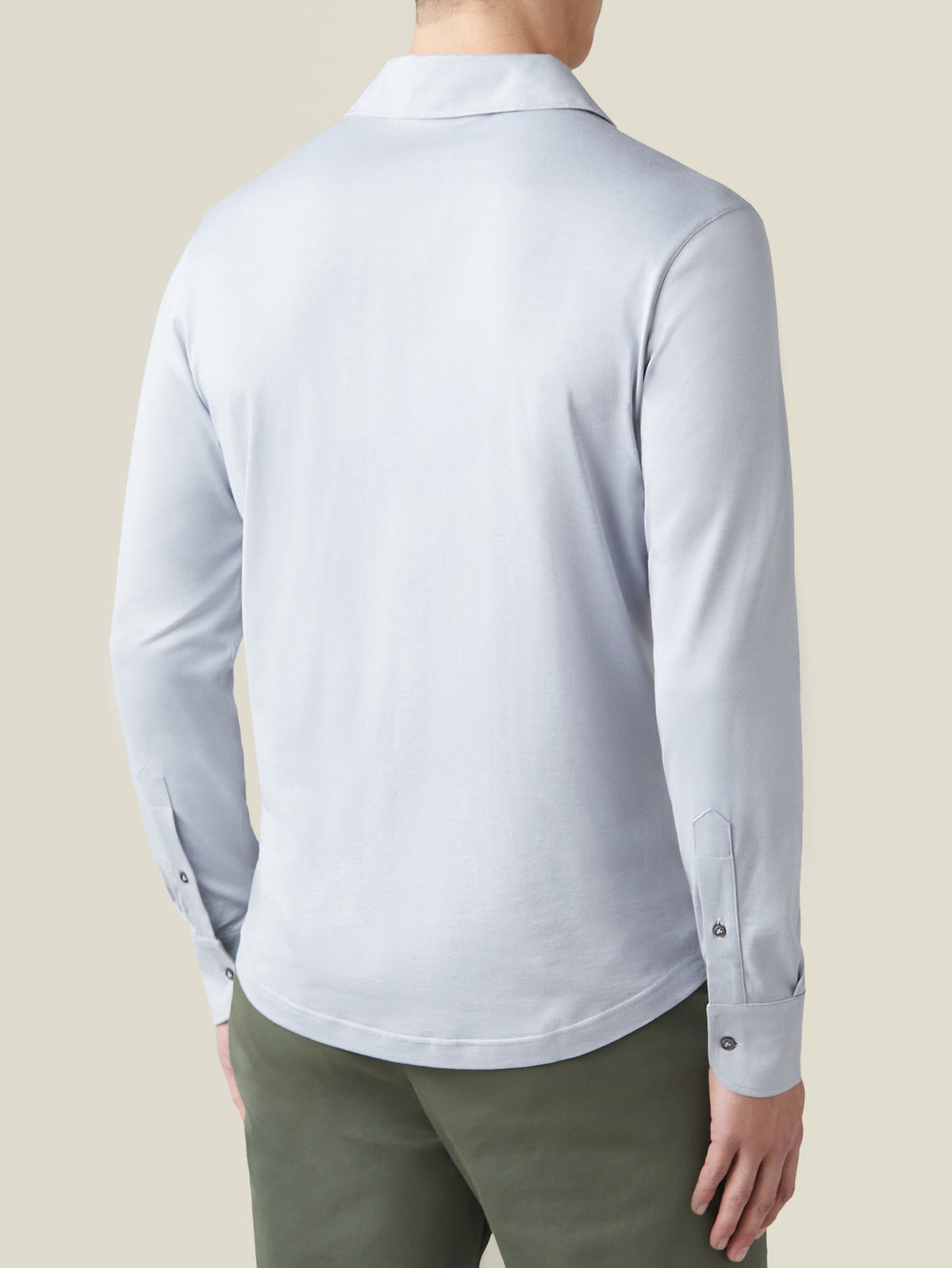 Back view of the Amalfi Silk-Cotton Polo Shirt in light grey, showcasing the fit across the back and the buttoned cuffs.