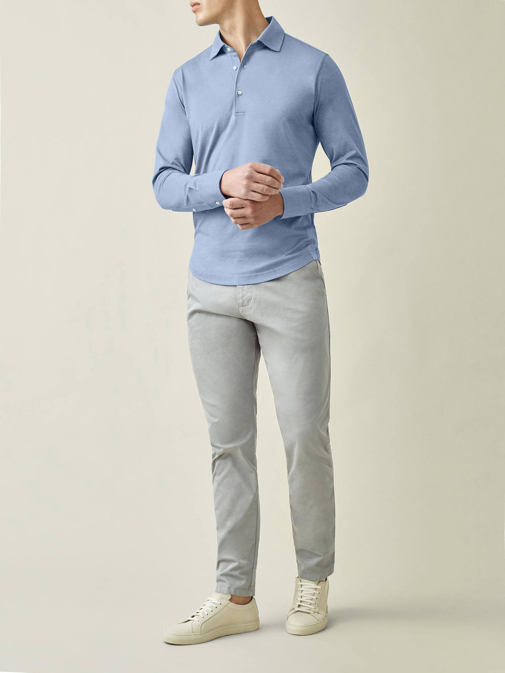 Full view of a model wearing the Luca Faloni Amalfi Silk-Cotton Polo Shirt in light blue with grey chinos.