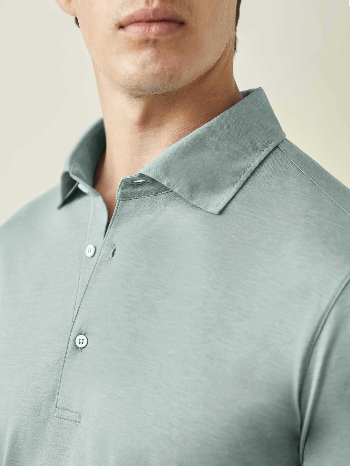 Close-up of the Marine Green Amalfi Silk-Cotton Polo Shirt, focusing on the collar, button placket, and fabric texture.