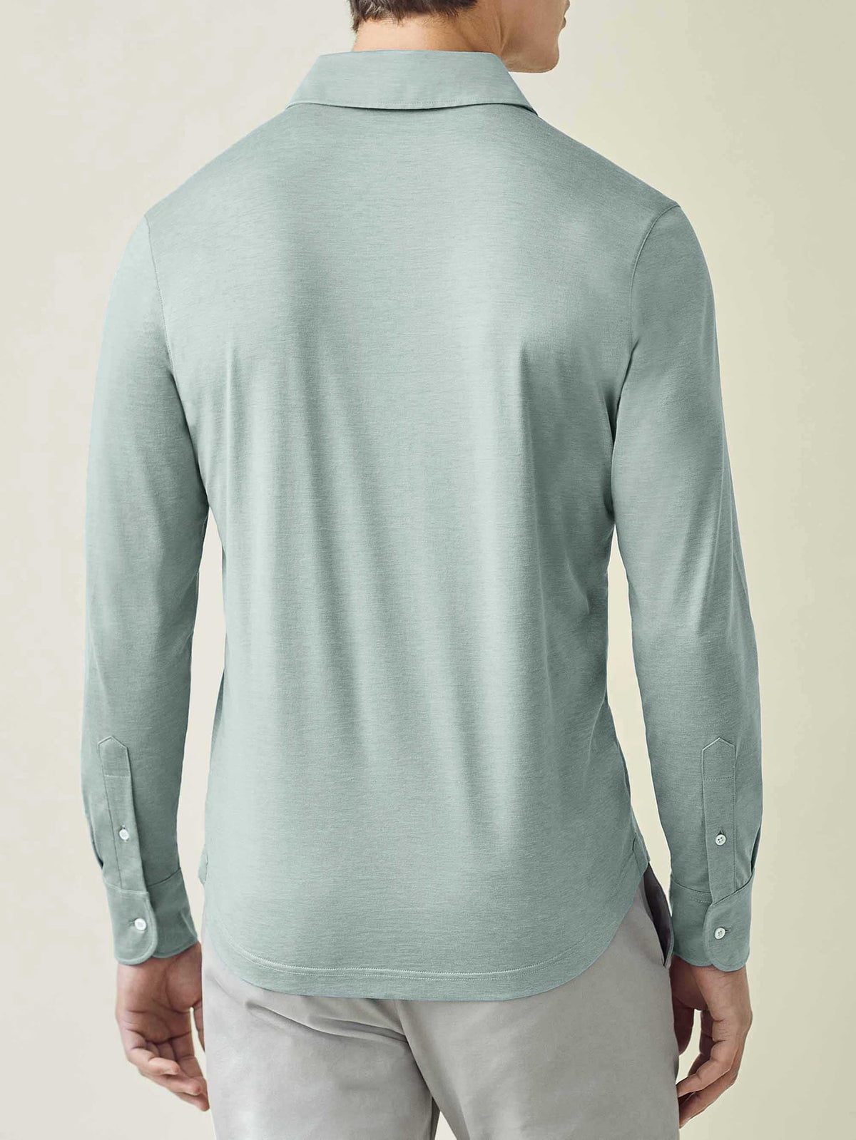 Back view of the Amalfi Silk-Cotton Polo Shirt in Marine Green, showcasing the slim fit and shirt-style cuffed sleeves.