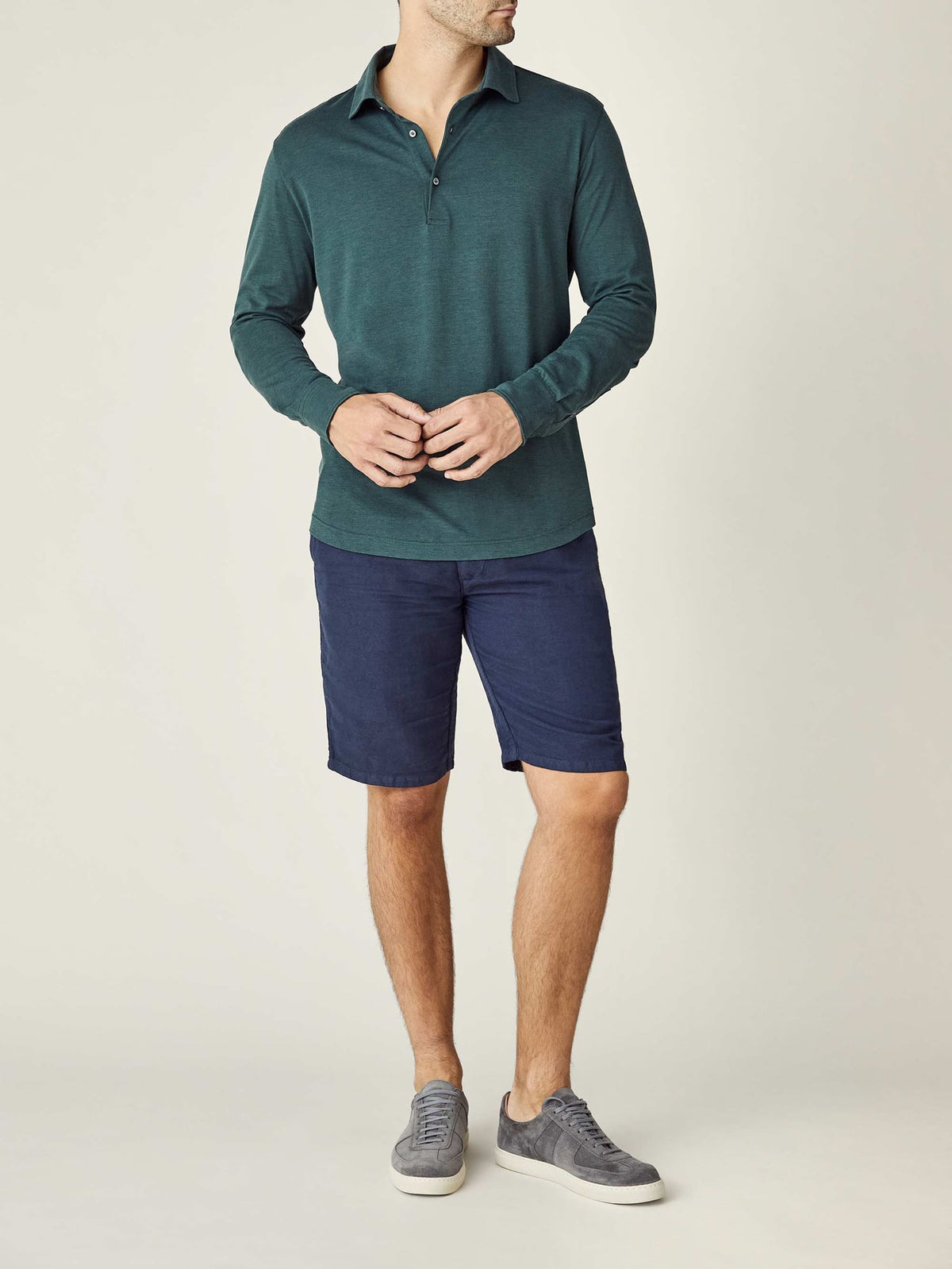 Full view of a model wearing the Emerald Green Amalfi Silk-Cotton Polo Shirt, styled with navy shorts and grey sneakers.
