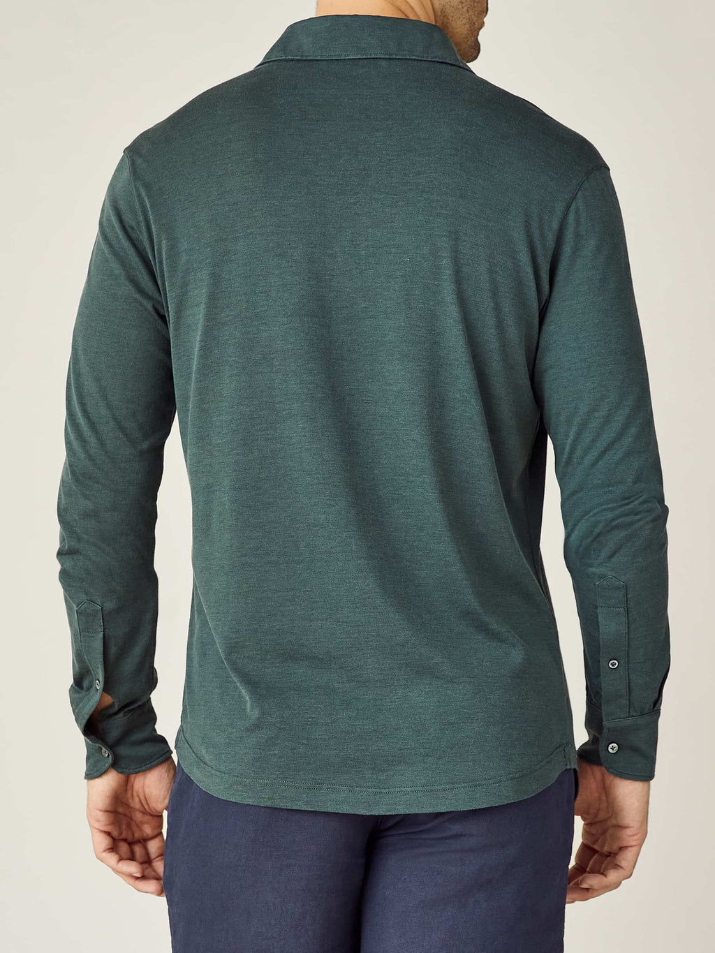 Back view of a model wearing the long-sleeved Amalfi Silk-Cotton Polo Shirt in Emerald Green.