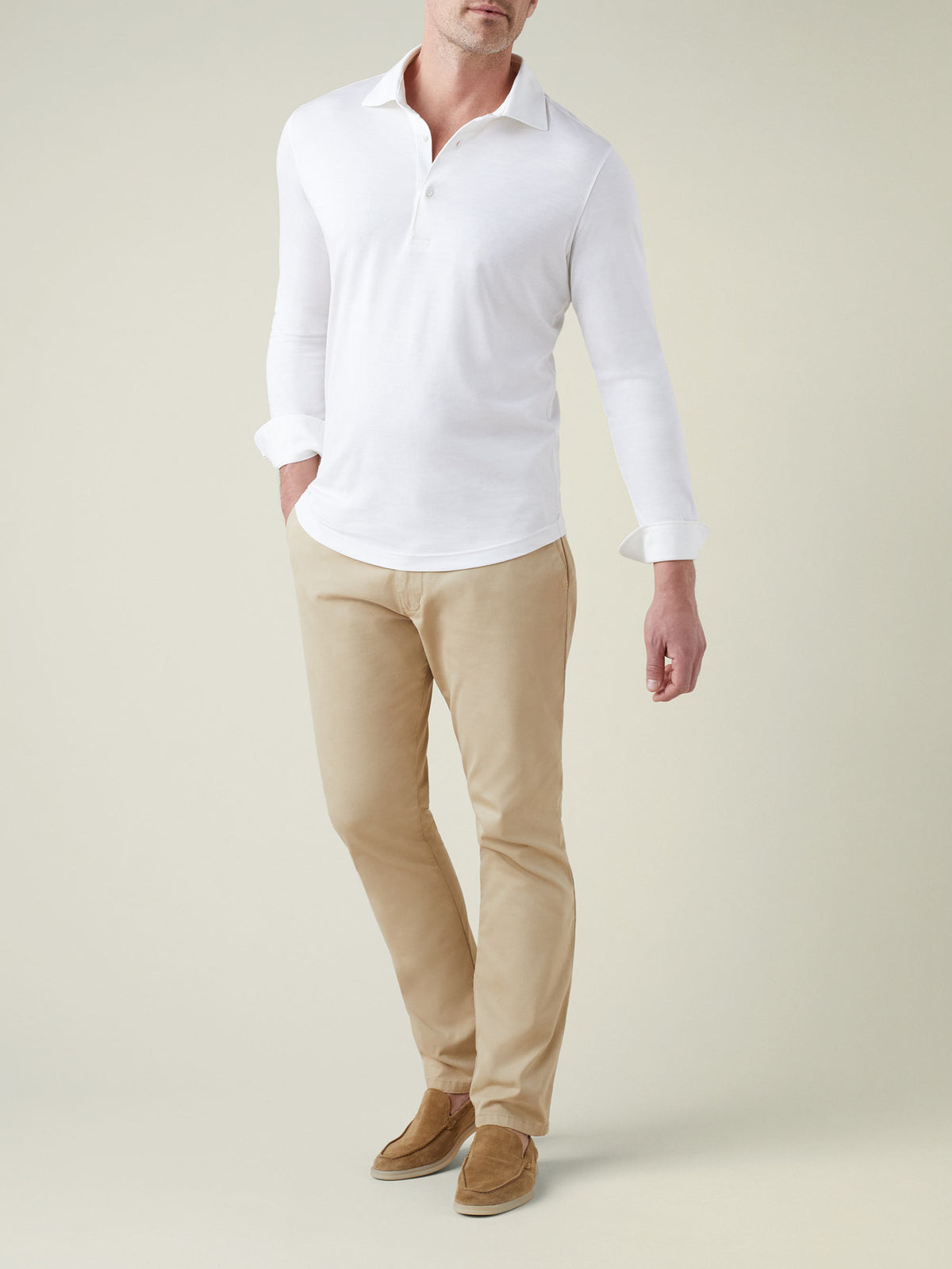 Front view of a model wearing Luca Faloni's white Amalfi Silk-Cotton Polo Shirt with beige chinos and tan suede loafers.