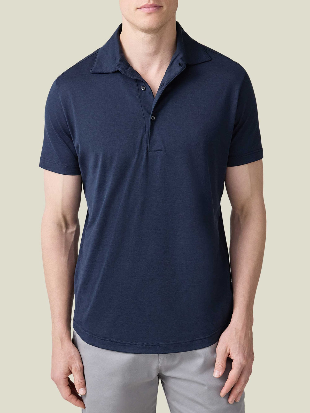 Front view of a man wearing the Luca Faloni Short-Sleeved Silk-Cotton Polo in Midnight Blue with light grey trousers.
