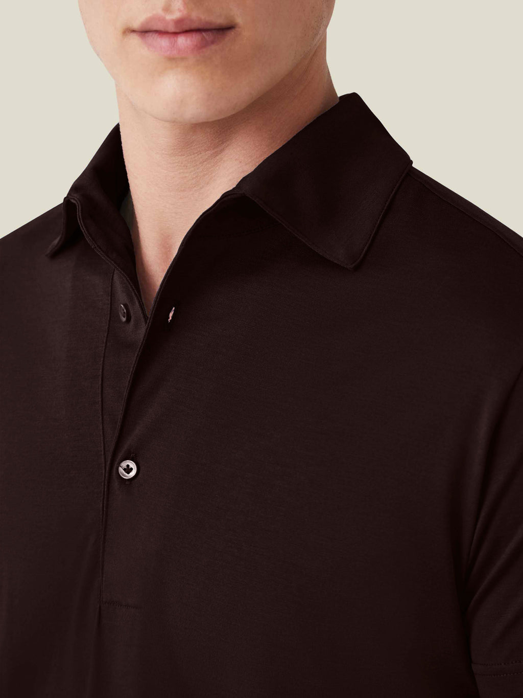 Close-up of a model wearing the Luca Faloni Short-Sleeved Silk-Cotton Polo in chocolate brown, showing the collar detail.