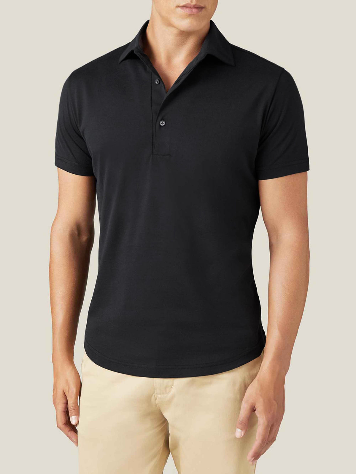 Front view of a model wearing the Luca Faloni black short-sleeved silk-cotton polo with light coloured trousers.