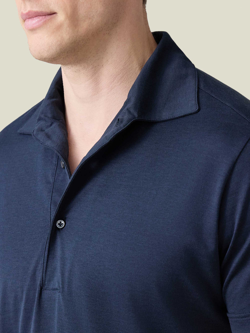 Detailed view of the 'Paramontura' collar and silk-cotton fabric of the short-sleeved polo in midnight blue.