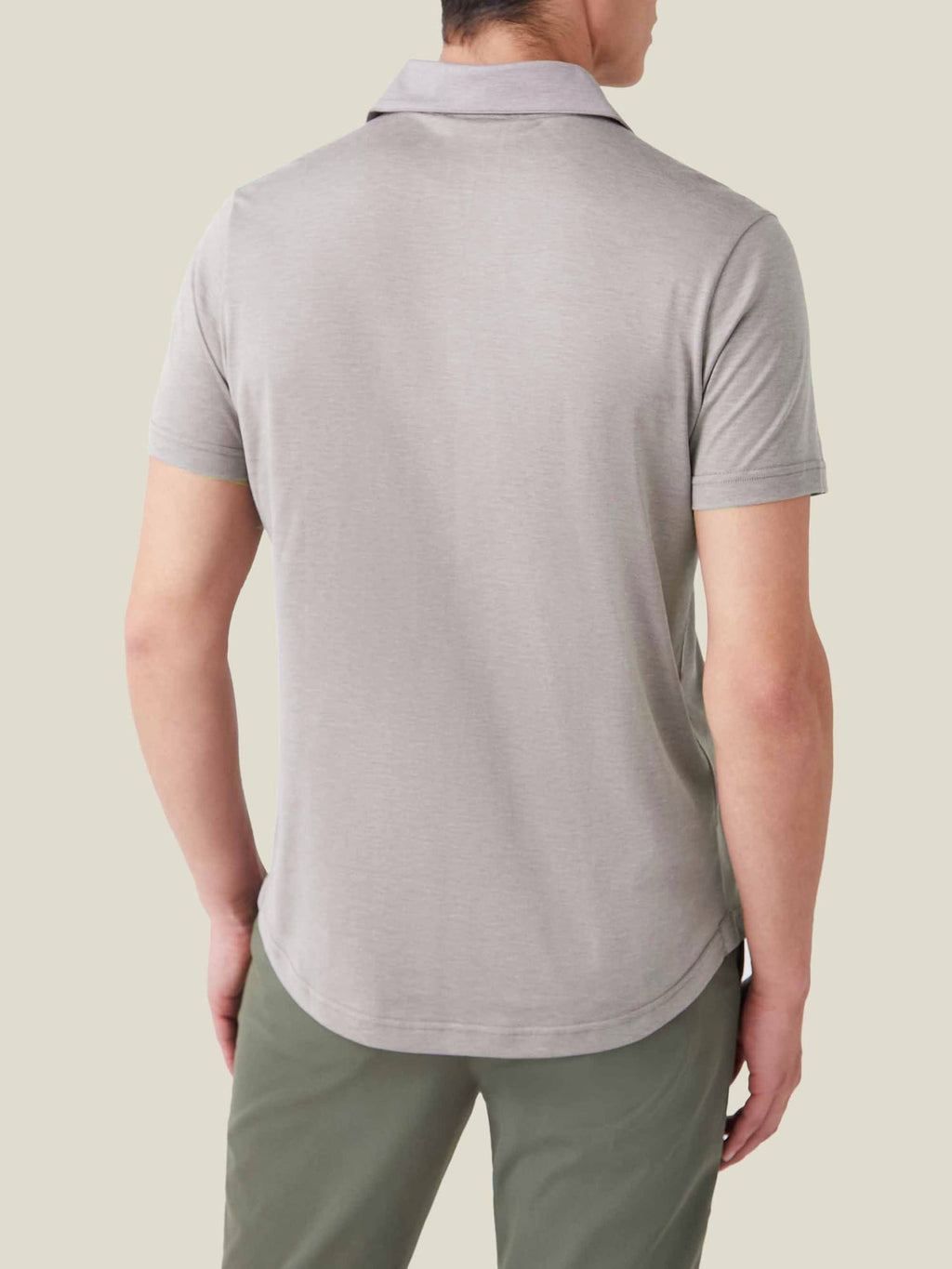 Rear view of a man wearing the Nocciola Brown short-sleeved silk-cotton polo, showing the relaxed fit and rounded hem.