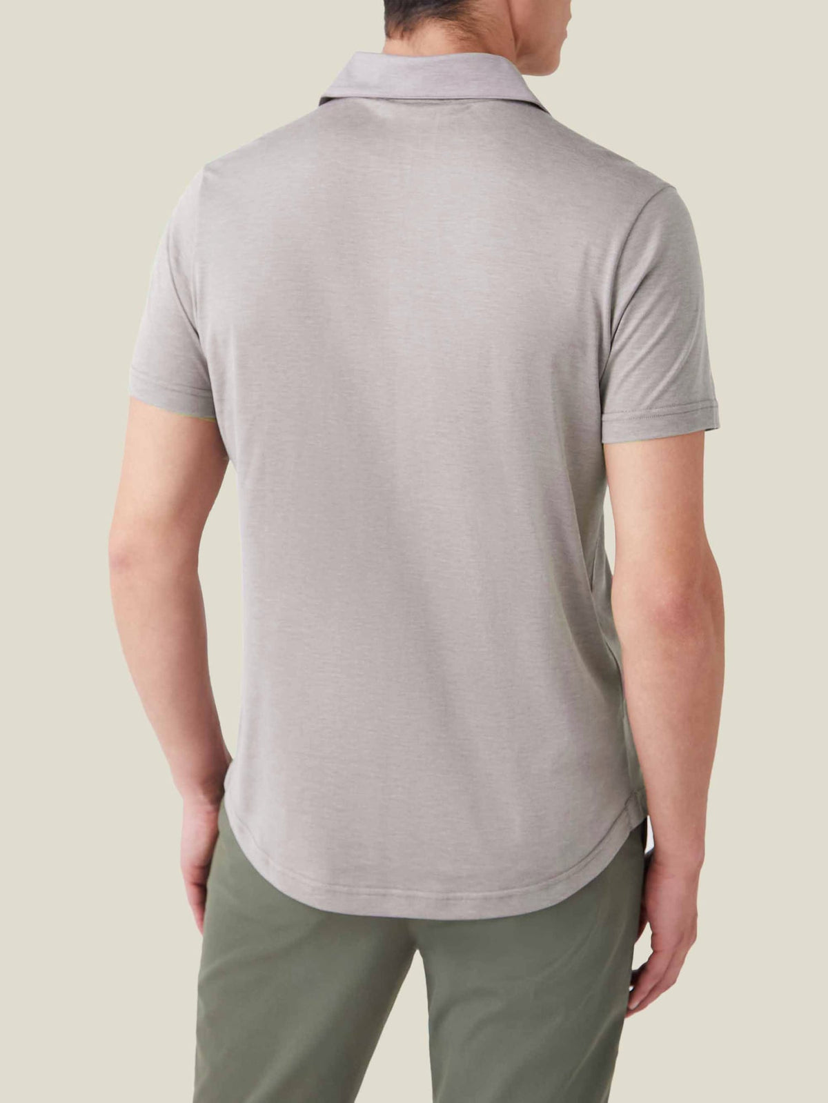 Rear view of a man wearing the Nocciola Brown short-sleeved silk-cotton polo, showing the relaxed fit and rounded hem.