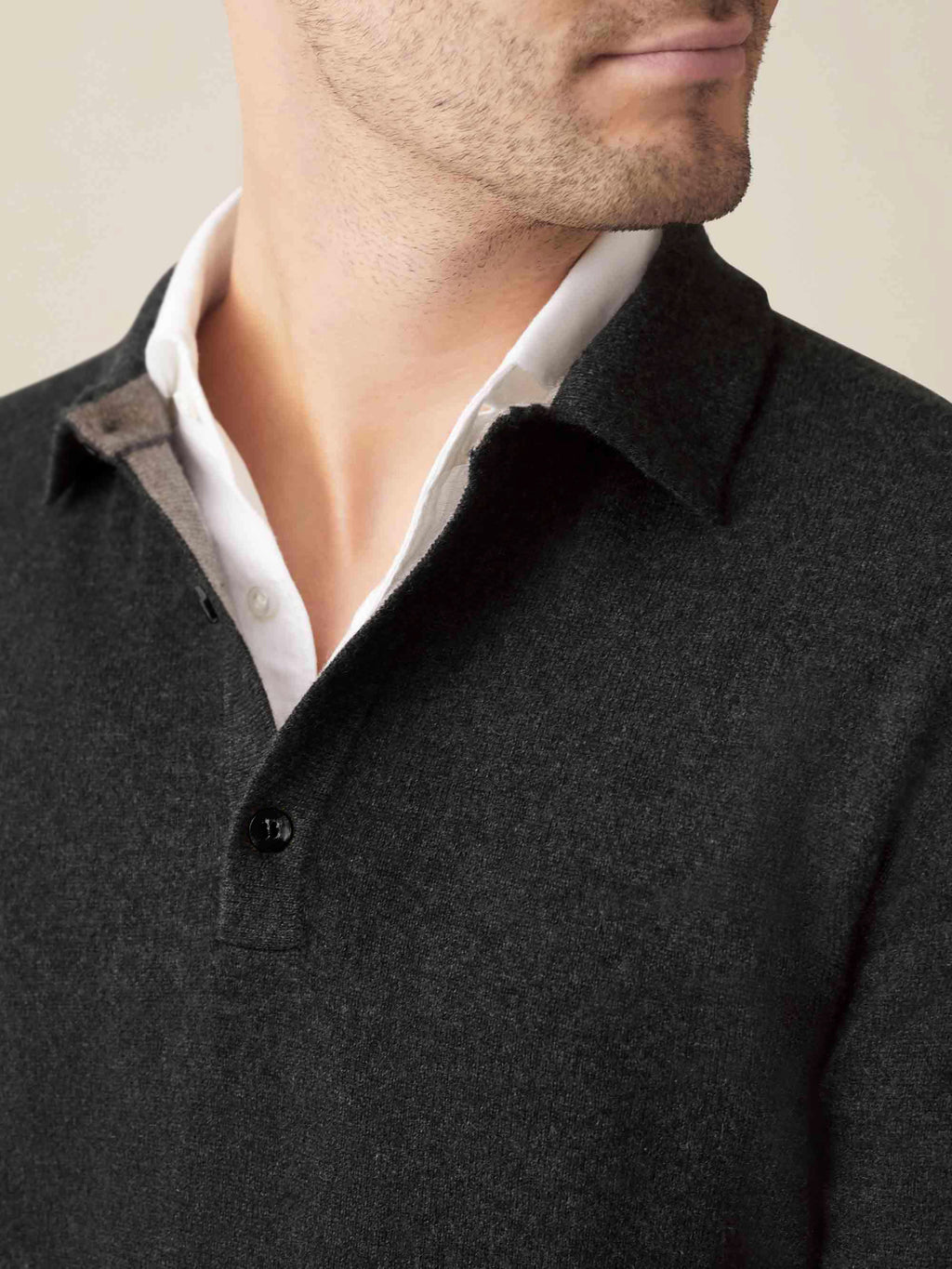 Close-up of the Luca Faloni charcoal grey cashmere polo sweater, showing the collar detail layered over a white shirt.