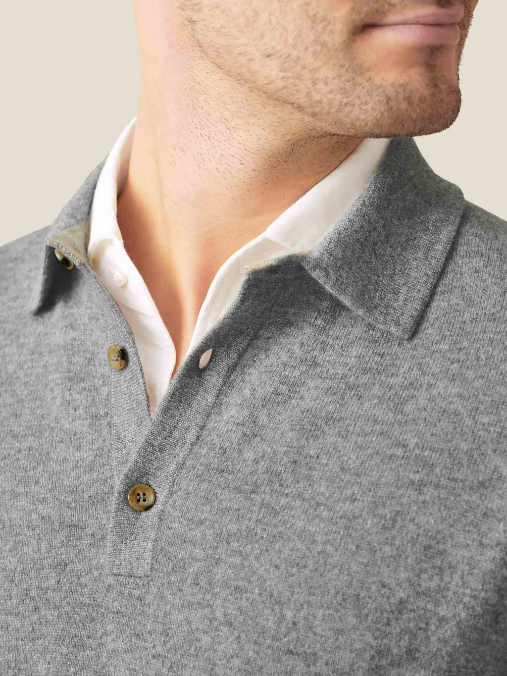 Close-up of a man wearing the Dolomiti Grey cashmere polo sweater, showing the classic collar and mother-of-pearl buttons.