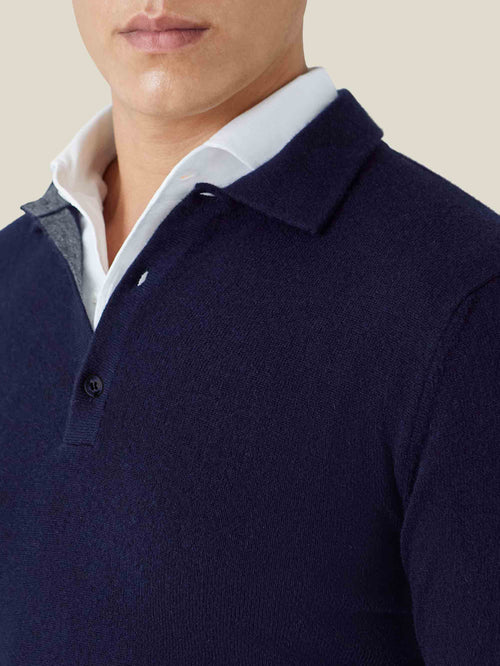 Close-up of the collar and placket of the midnight blue cashmere polo sweater, layered stylishly over a white shirt.