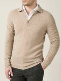 A model wears the Cashmere Polo Sweater in camel beige, layered over a white collared shirt and dark trousers.