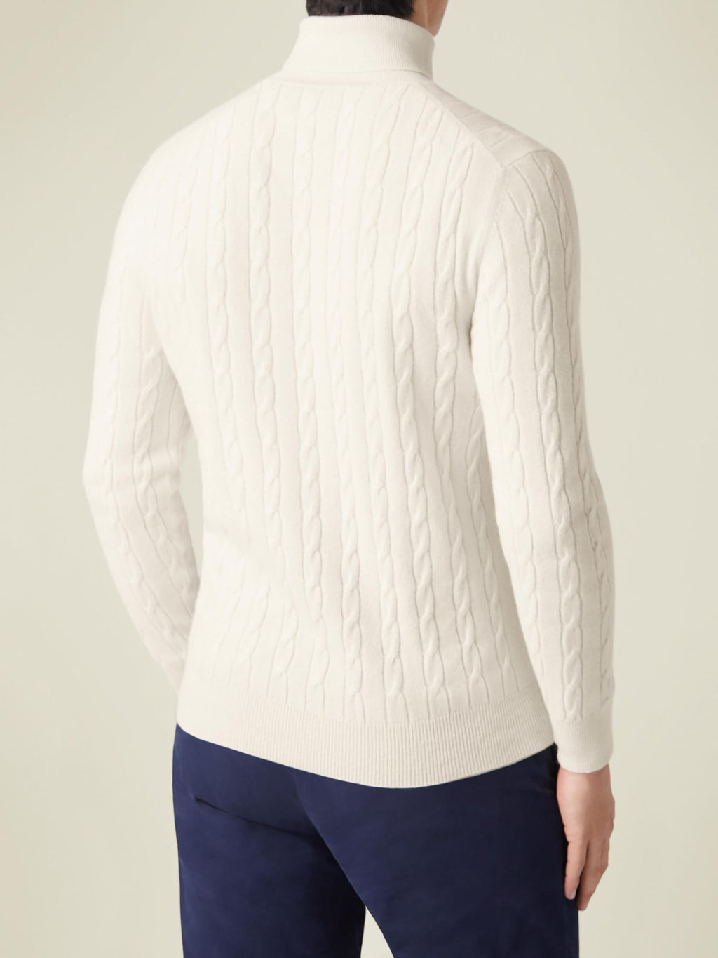 Back view of a man wearing the Ivory Cashmere Cable Knit Roll Neck, showcasing the intricate texture and fit.