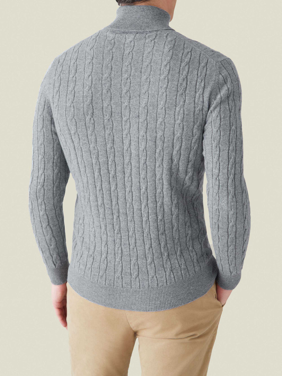 Back view of a model wearing the Dolomiti Grey Cable Knit Roll Neck, showing the sweater's fit and texture.