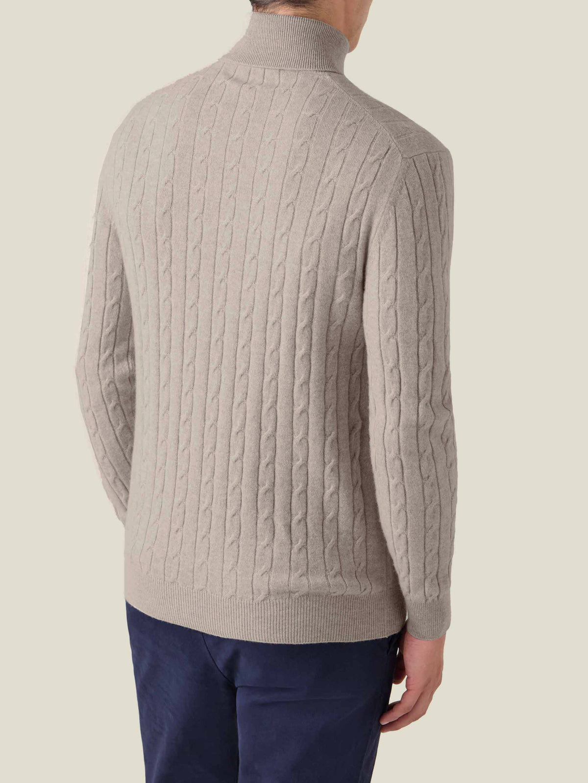 Back view of the Luca Faloni Cable Knit Roll Neck in almond, worn by a model.