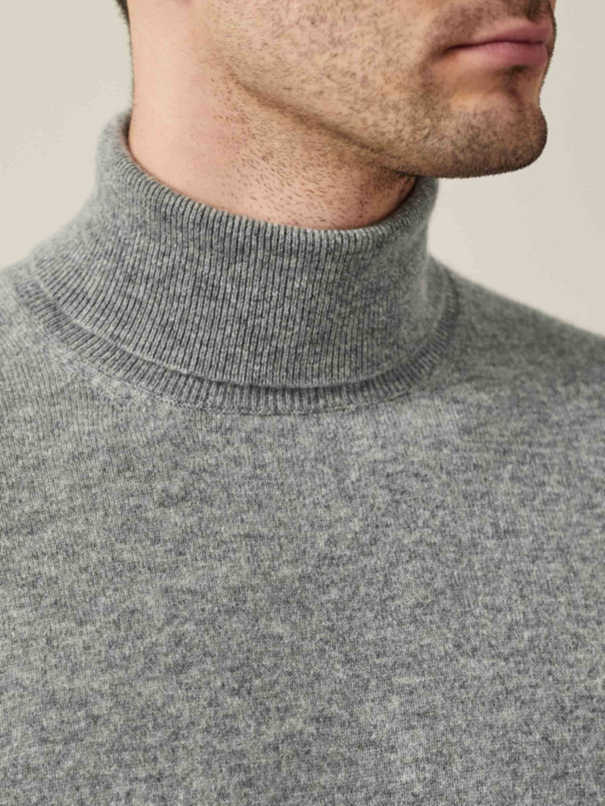 Close-up of a man wearing a Luca Faloni Dolomiti Grey pure cashmere roll neck, showing the ribbed collar and texture.