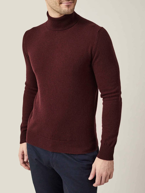 Front-three-quarter view of a model wearing Luca Faloni's Lava Red Cashmere Roll Neck with dark trousers.