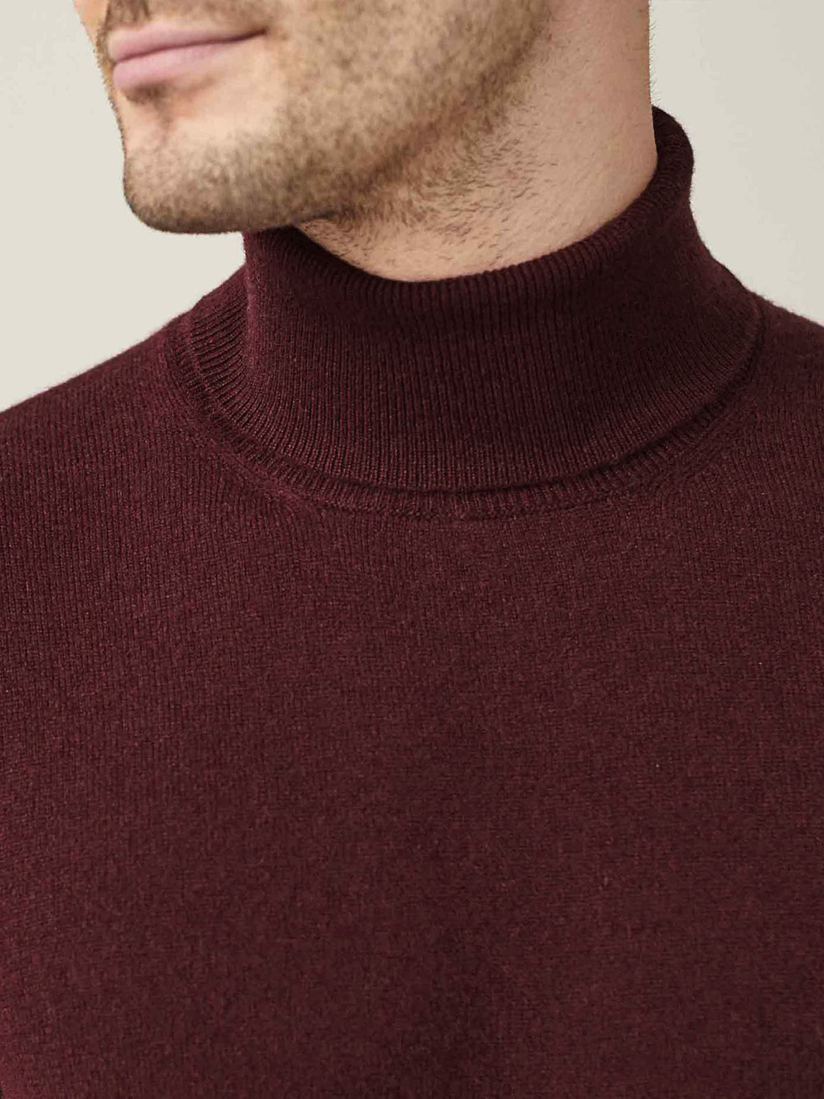 Close-up of a man wearing the Luca Faloni Lava Red Cashmere Roll Neck, highlighting the ribbed collar and soft fabric.