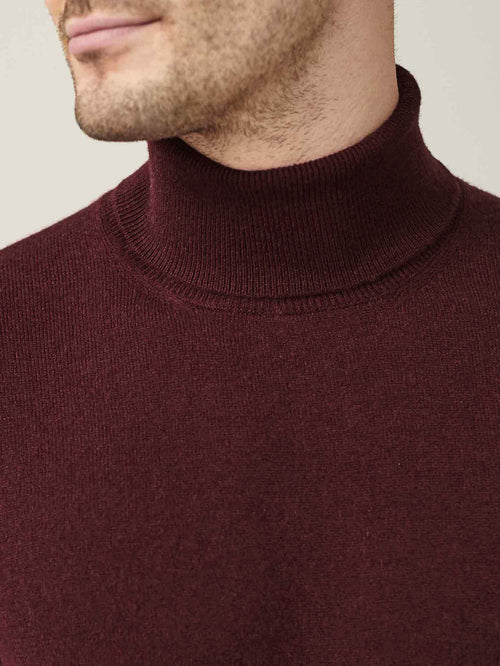Close-up of a man wearing the Luca Faloni Lava Red Cashmere Roll Neck, highlighting the ribbed collar and soft fabric.