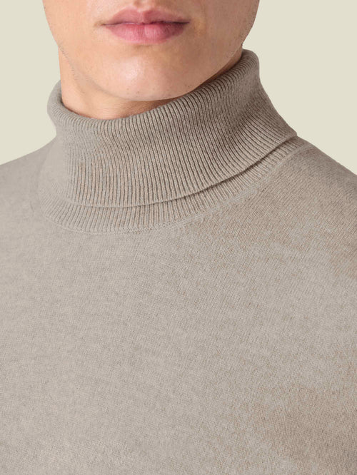 Close-up of the ribbed collar on the Luca Faloni Cashmere Roll Neck in almond, worn by a model.