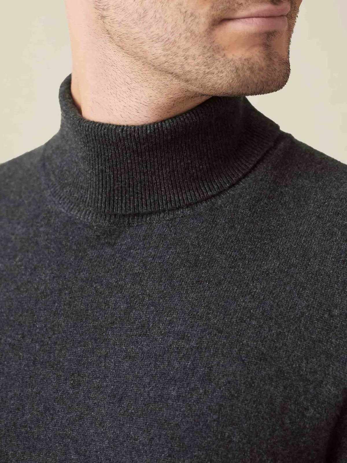 Close-up of the Luca Faloni charcoal grey cashmere roll neck, showing the detailed ribbed knit of the collar.