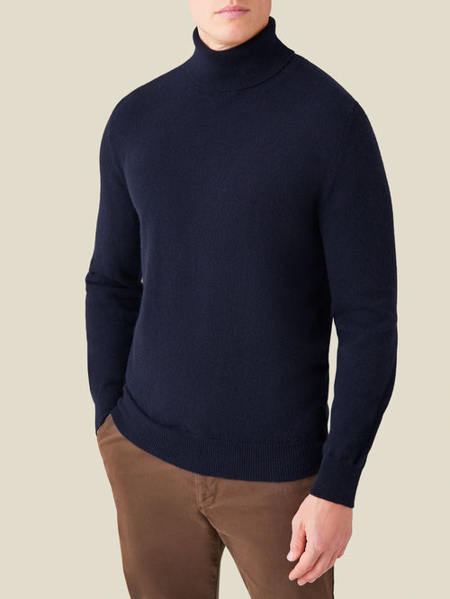 Front view of a model wearing the Luca Faloni Cashmere Roll Neck in midnight blue.