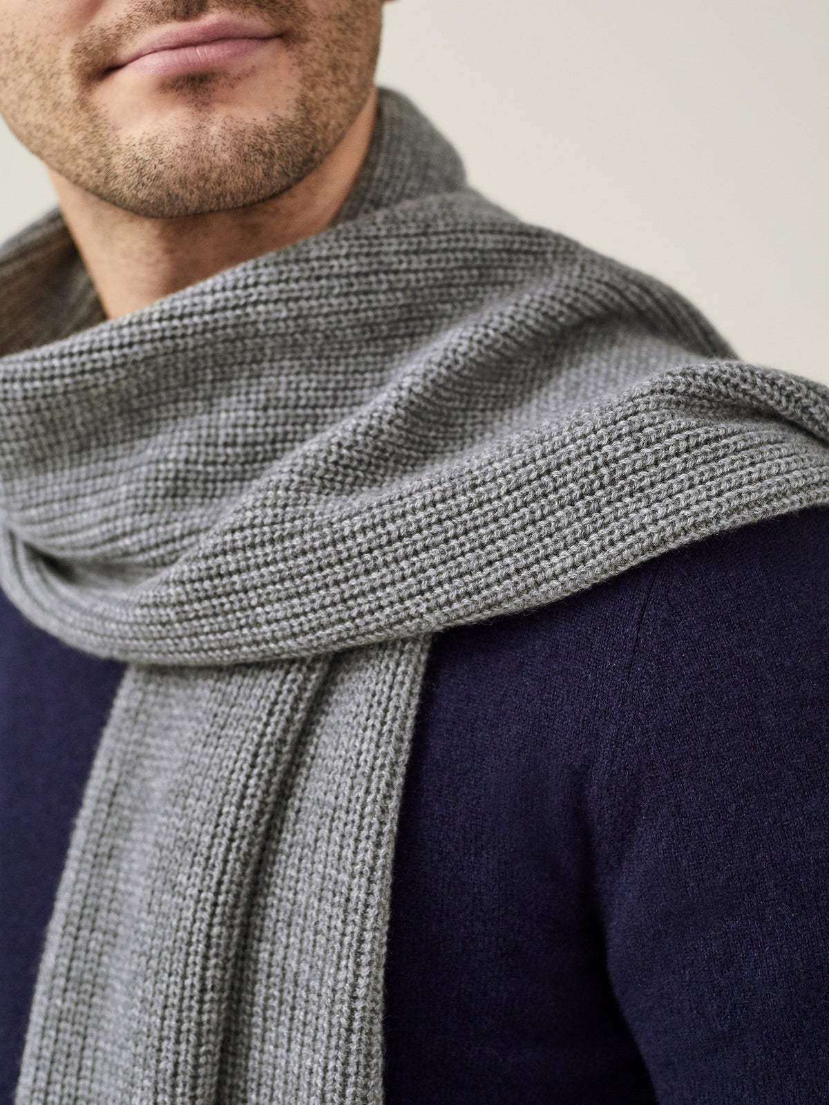 Close-up of a model wearing the Dolomiti Grey Chunky Knit Cashmere Scarf, highlighting its ribbed texture.