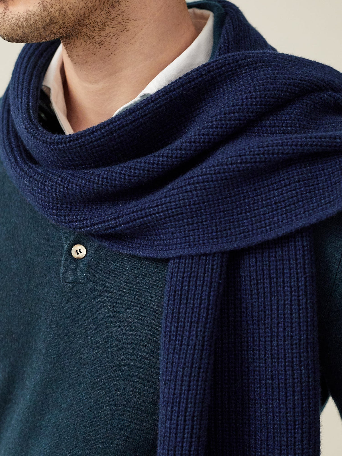 A close-up of a model wearing the Chunky Knit Cashmere Scarf in Midnight Blue, highlighting its soft, ribbed texture.