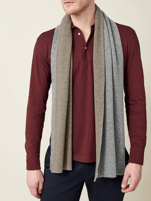 A front view of a model wearing the Double-Faced Cashmere Scarf in Grey and Brown, styled over a burgundy polo shirt.