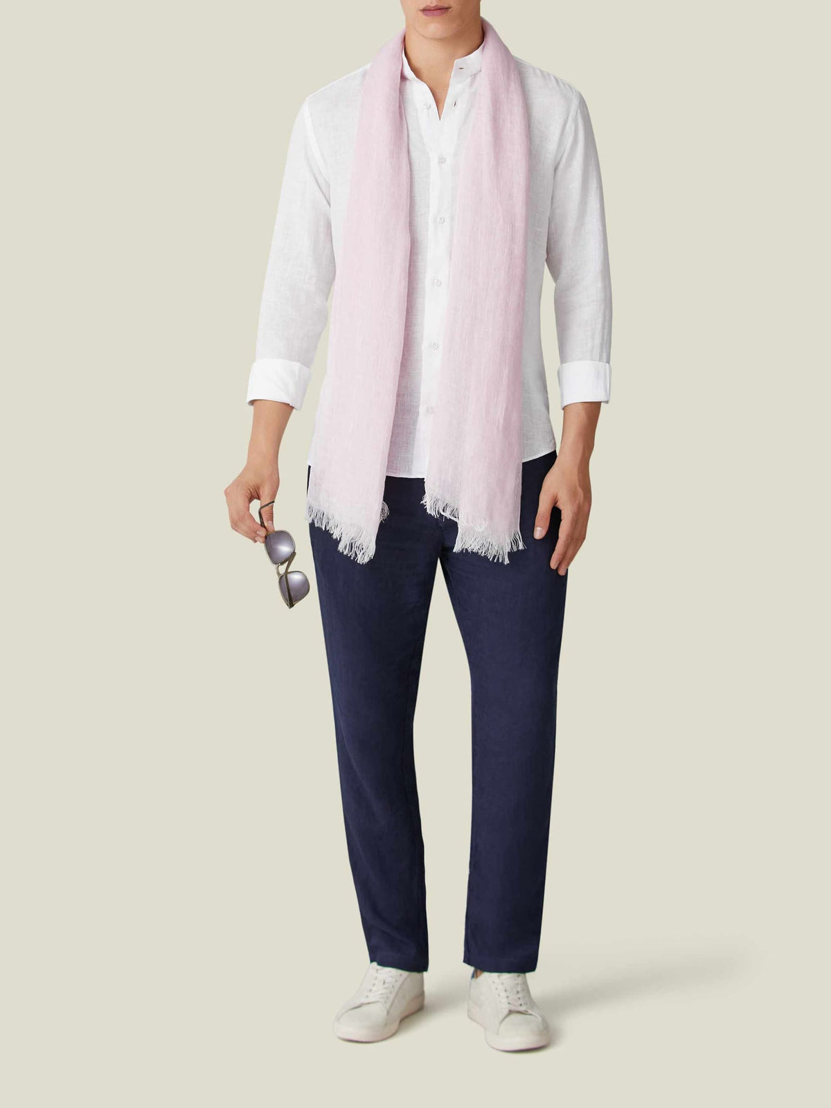 Front view of a model wearing the light pink Linen Scarf with a white shirt, navy trousers, and white trainers.