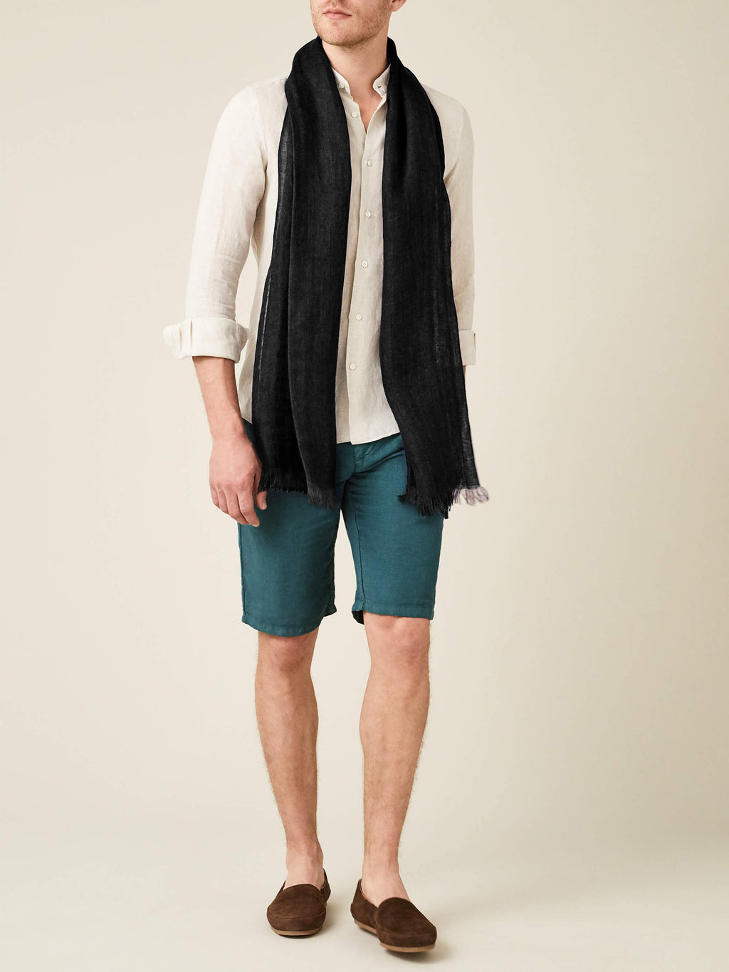 Model wearing the Black Linen Scarf with a cream linen shirt, teal shorts, and brown suede loafers.