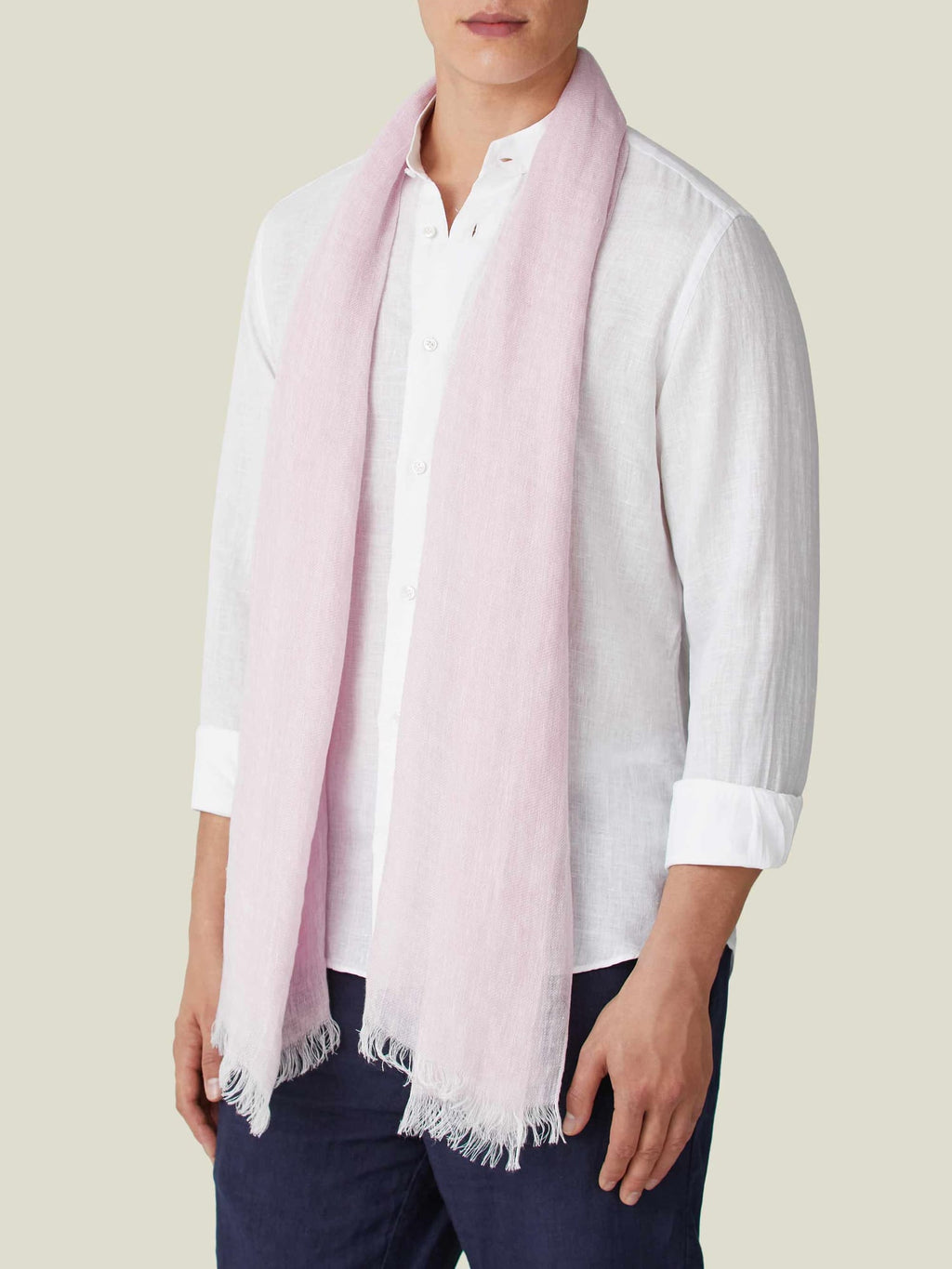A front view of a model wearing the Luca Faloni Light Pink Linen Scarf over a white shirt and dark trousers.