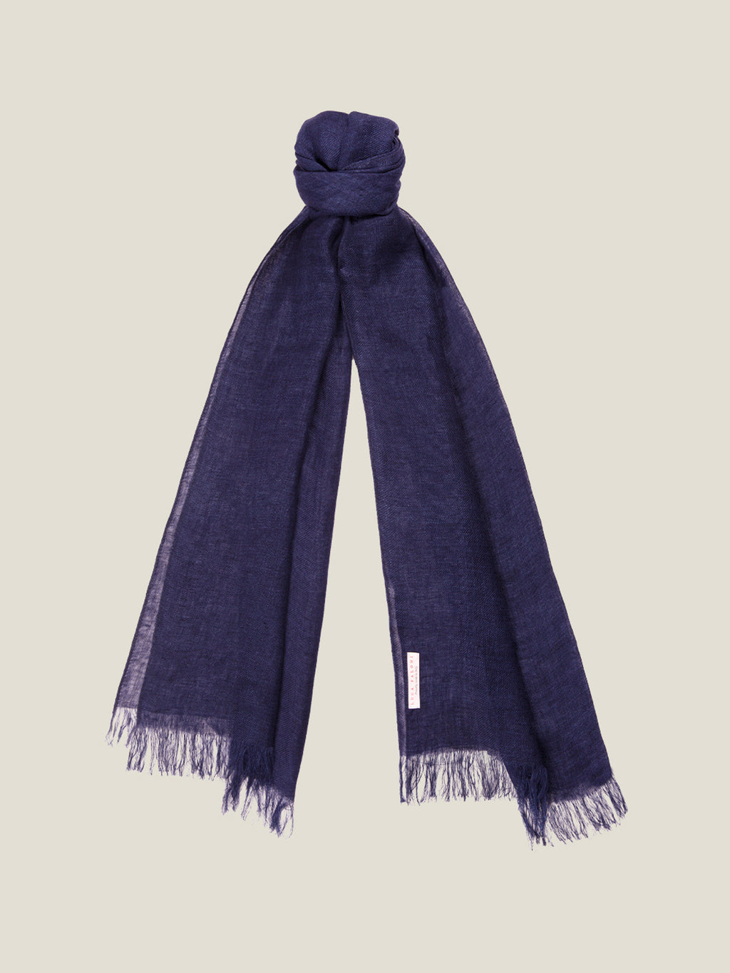 The Luca Faloni Linen Scarf in navy blue, tied at the top to highlight its lightweight linen texture and fringed ends.