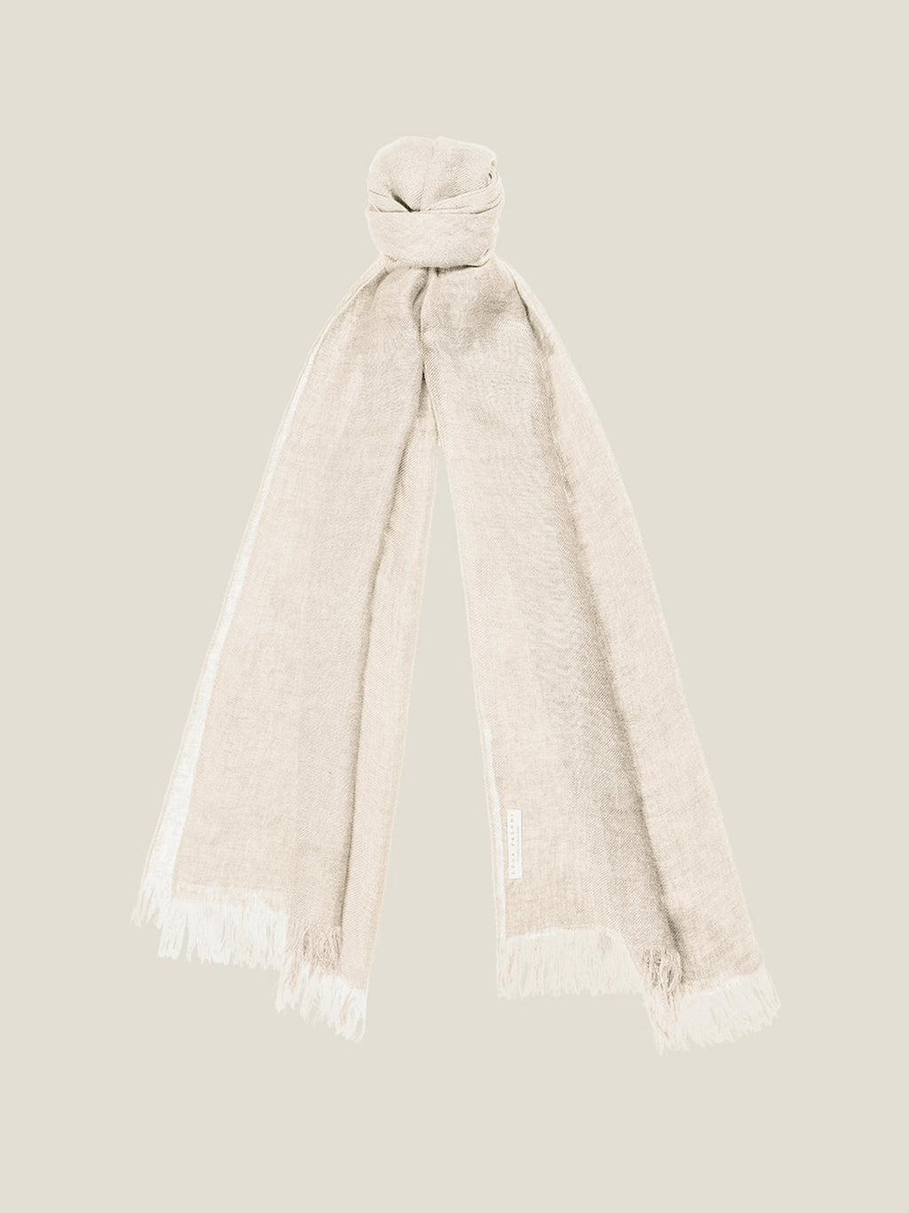 A sand-coloured linen scarf from Luca Faloni, tied in a knot, showing its lightweight fabric and fringed ends.