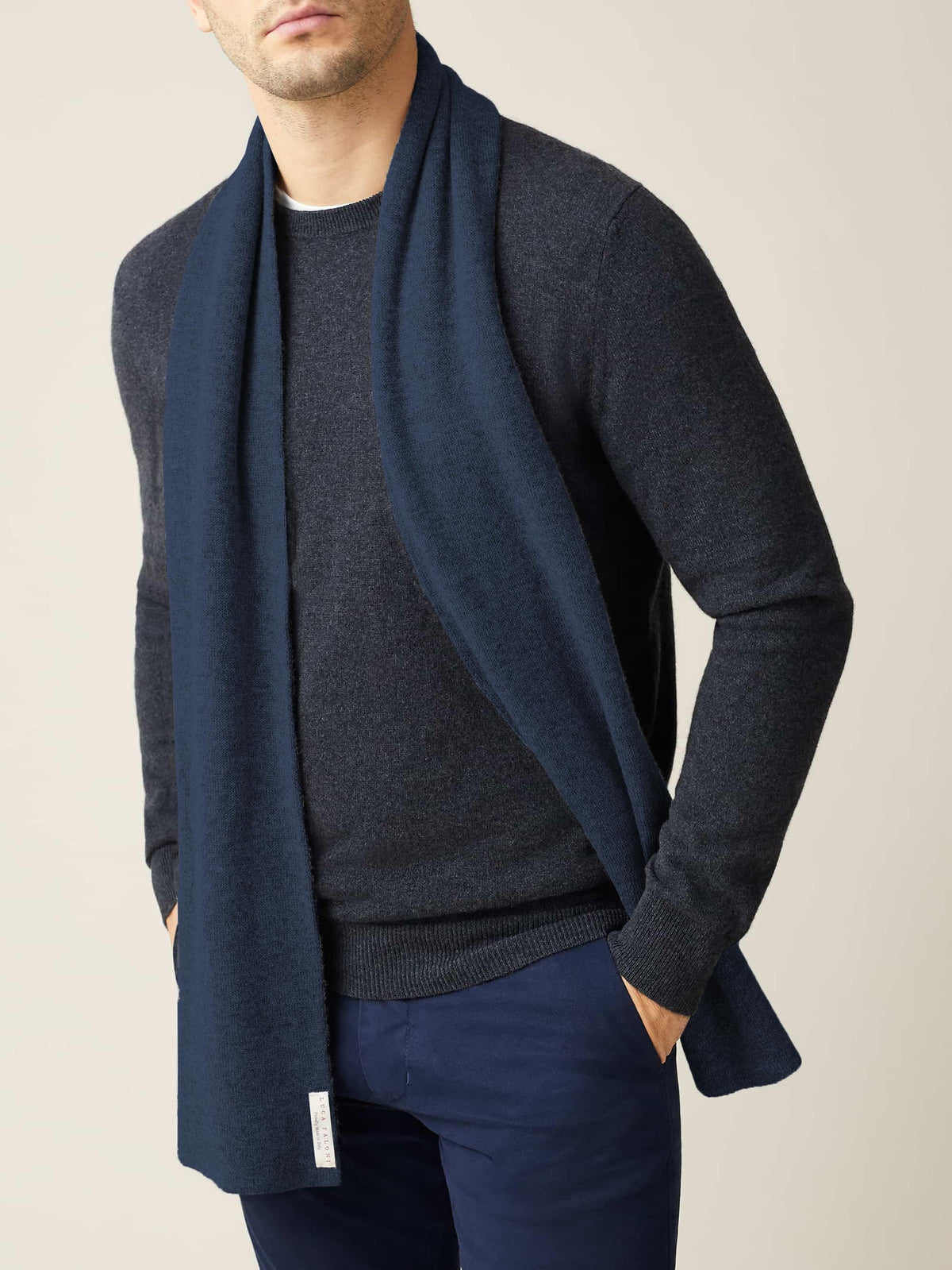 Front view of a model wearing the Luca Faloni Atlantic Blue Cashmere Scarf over a dark grey crew neck sweater.